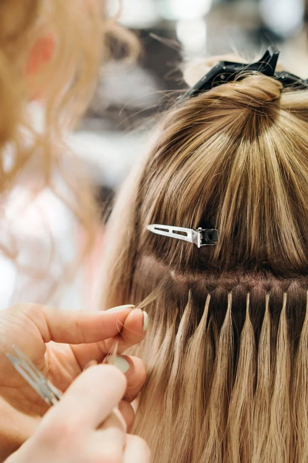 Hairstylist applying the extension to the woman
