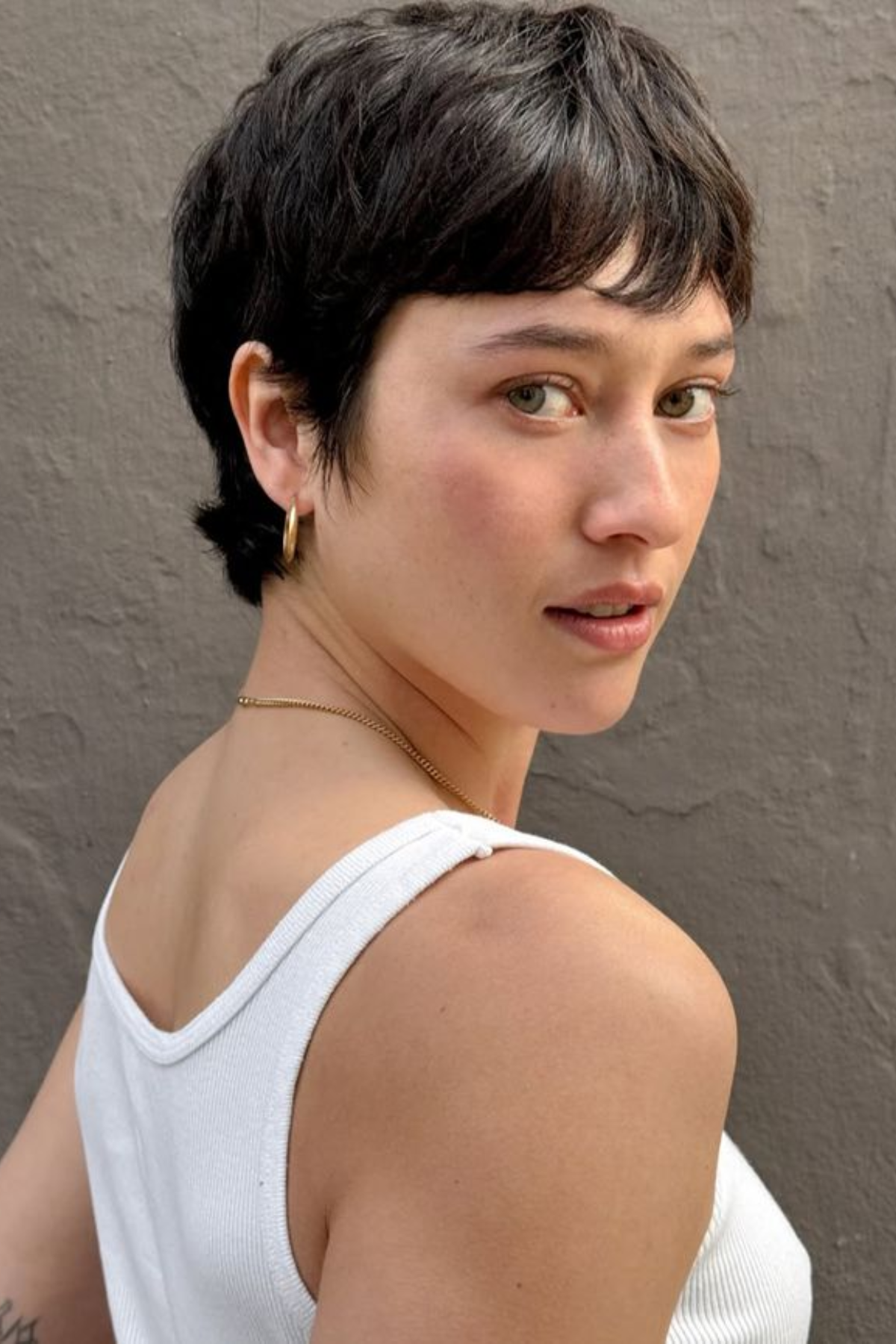 Girl wearing a Pixie Cut with Texture haircut, featuring short layered strands for maximum cooling and effortless styling.