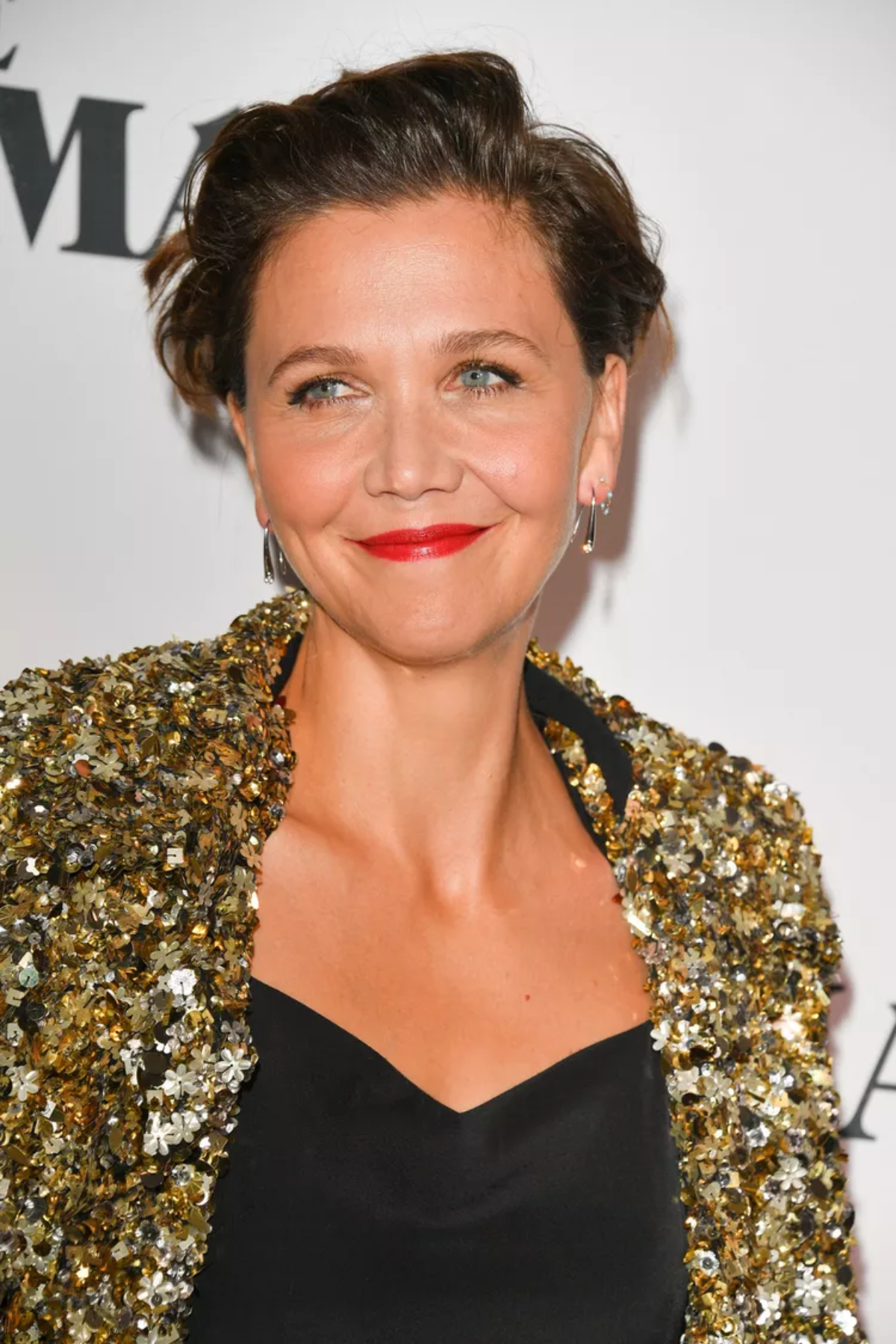 Front-facing image of a person wearing Feathered Crown Pixie for Grown-Out Look, showcasing short, softly styled layers with feathered lift at the crown and a polished, swept-back finish.