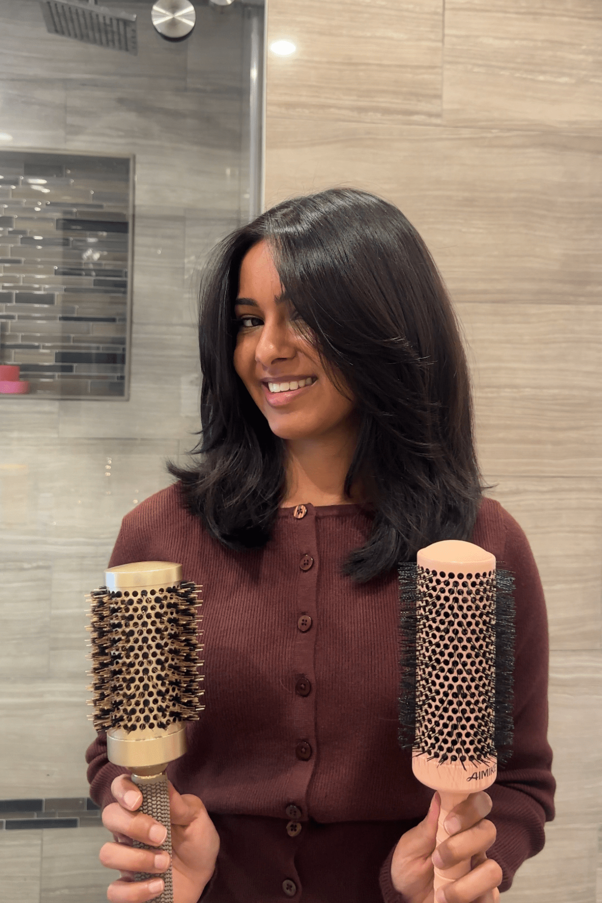 Jen smiling holding up both Aimike round brushes