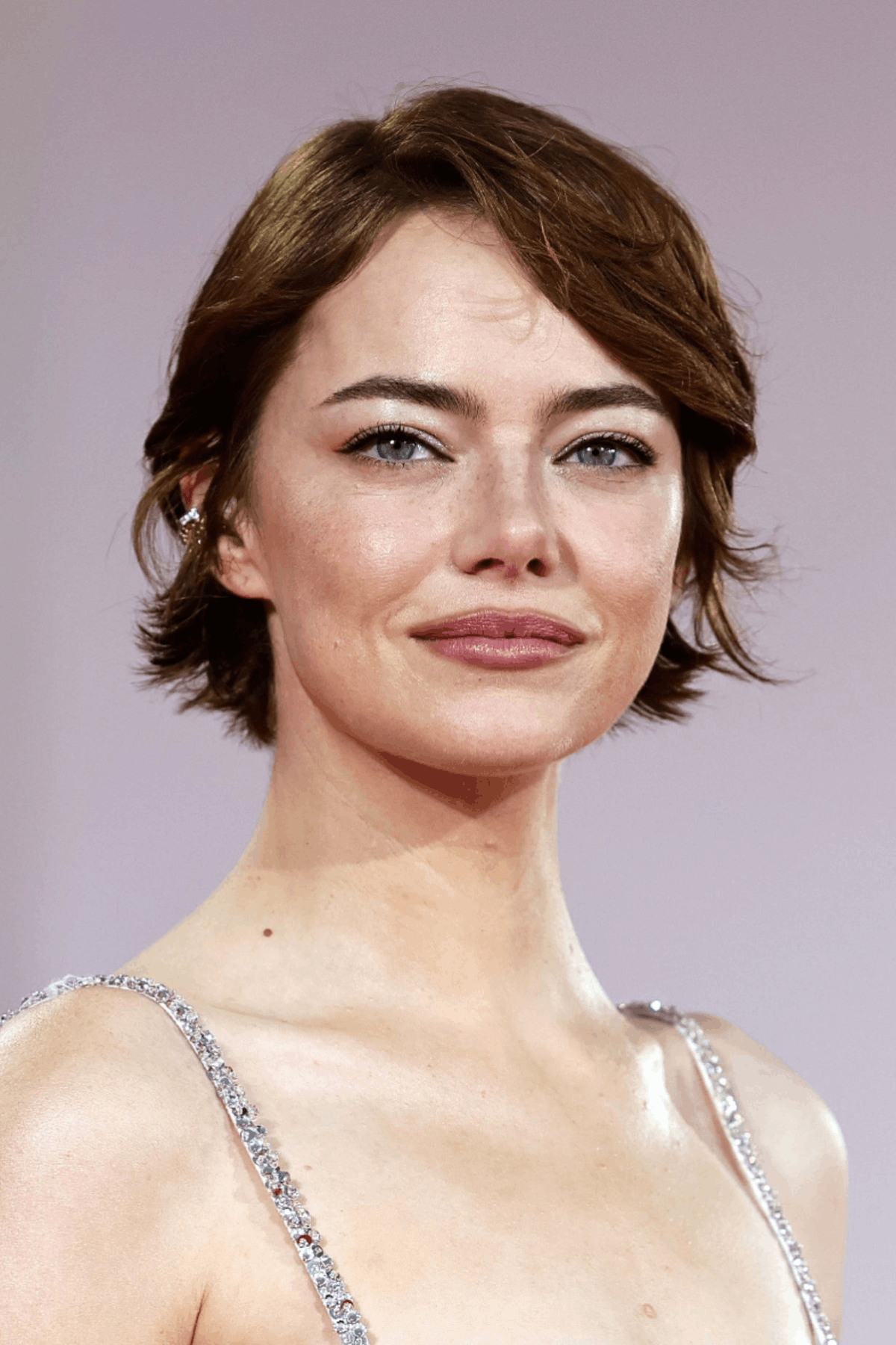 Woman with a short feathered haircut, featuring soft, flipped-out layers and airy texture for a modern, voluminous finish.