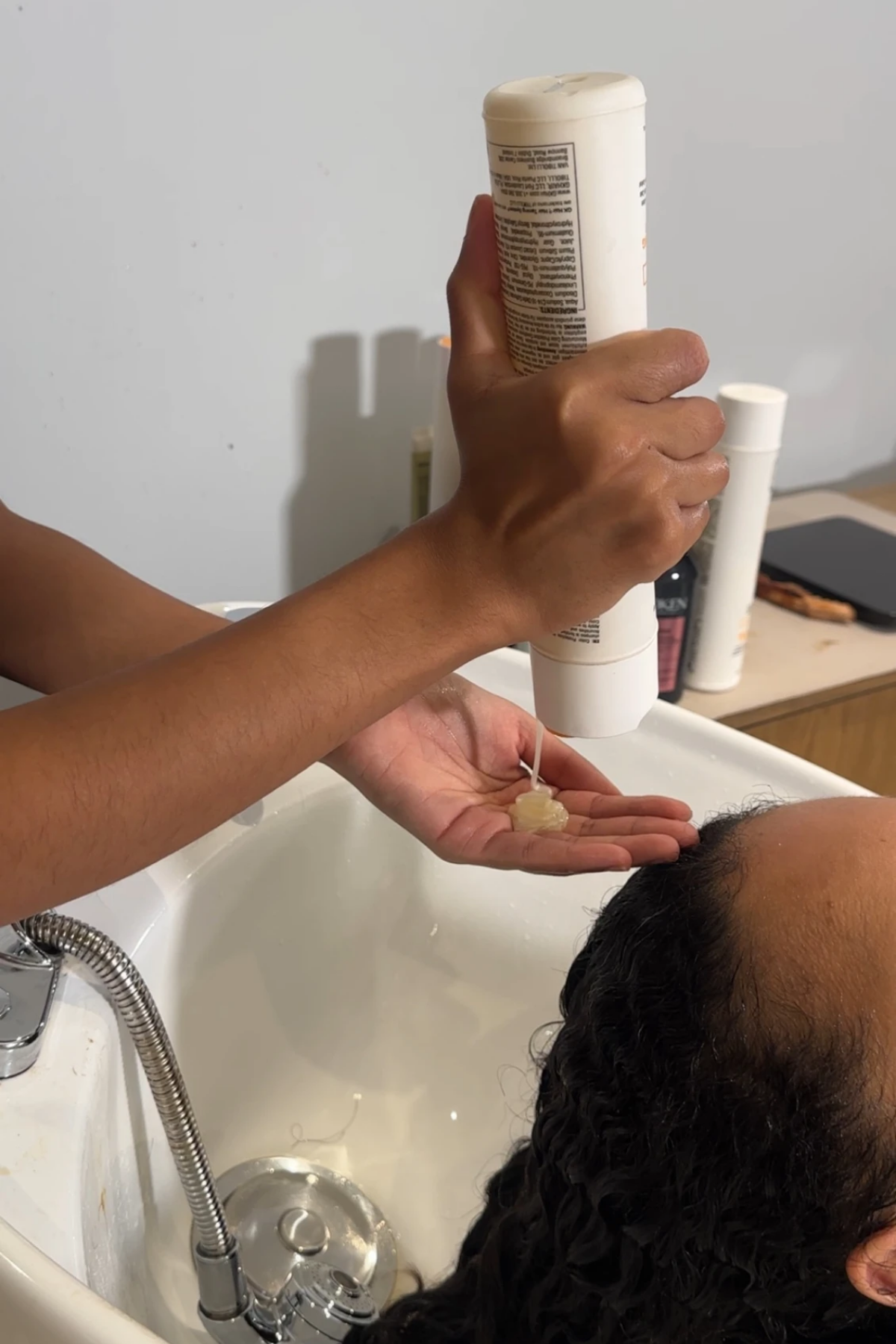 Woman rinsing the hair of another woman