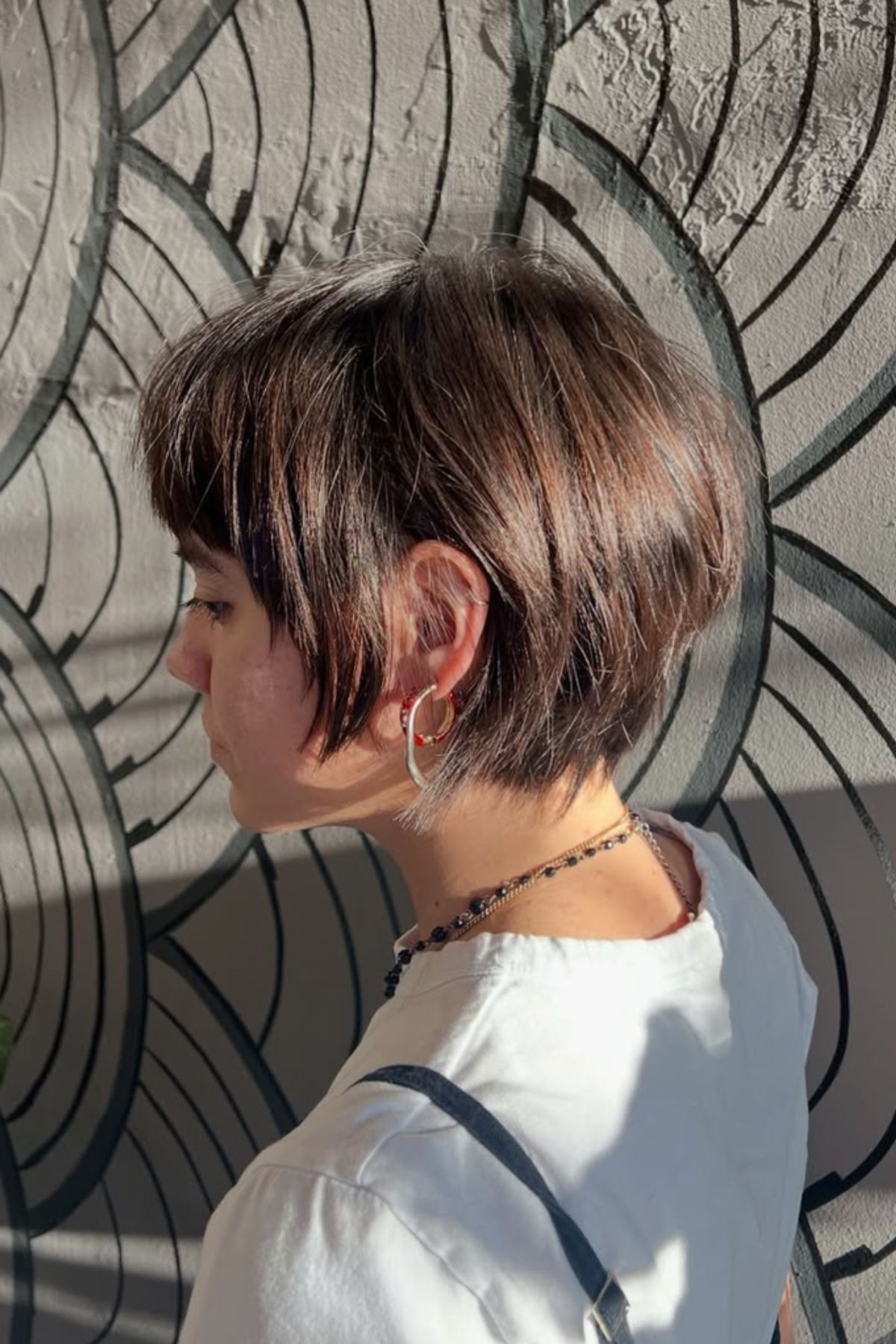 Woman wearing a Polished Bixie for Straight Hair haircut, featuring sleek smooth strands and a refined finish.