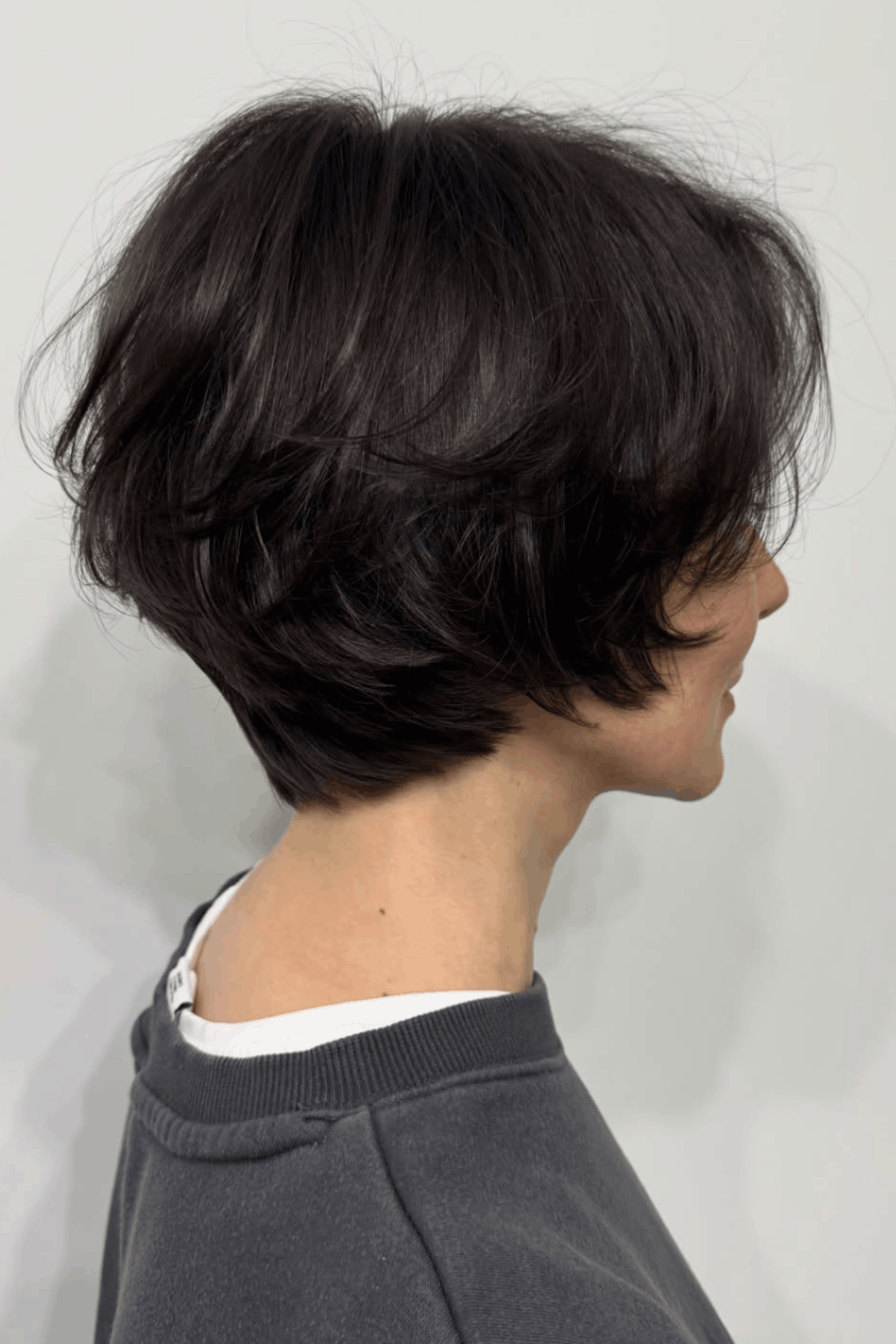 Back and side view of a brunette short layered bob for thick hair, featuring stacked layers and natural movement for added volume.