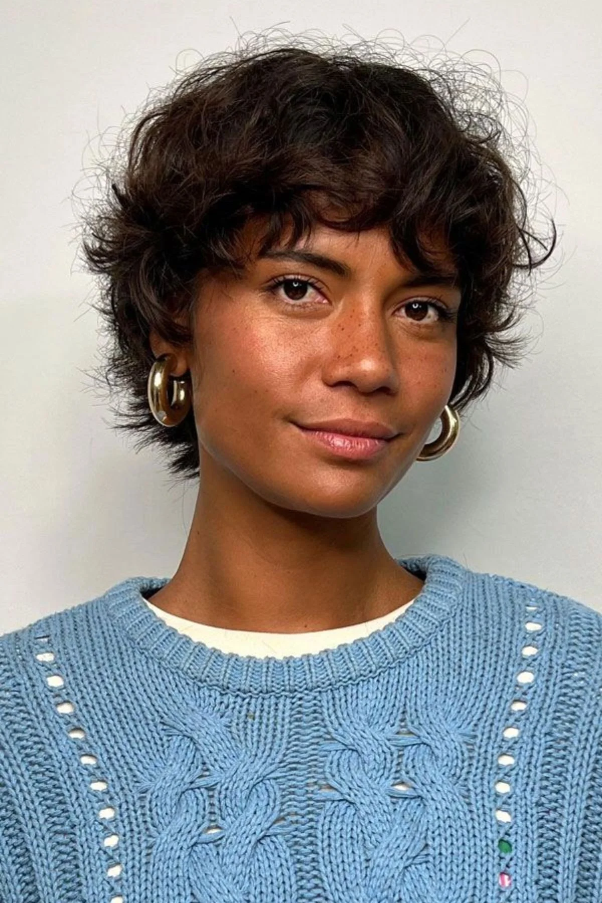 Girl with a Curly Bixie Haircut, combining defined curls with a short bixie structure for bouncy texture.
