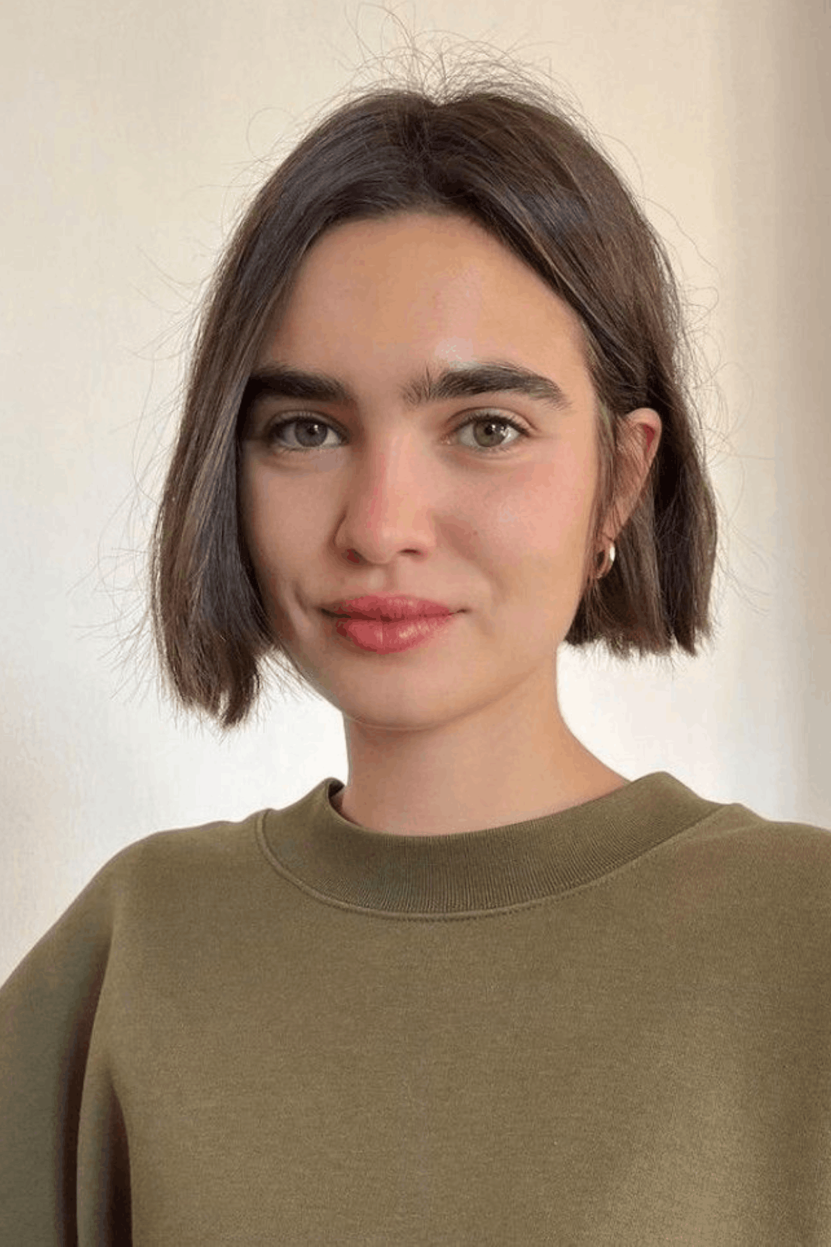 Woman with a classic French bob, cut at jaw length with blunt ends and subtle natural texture.