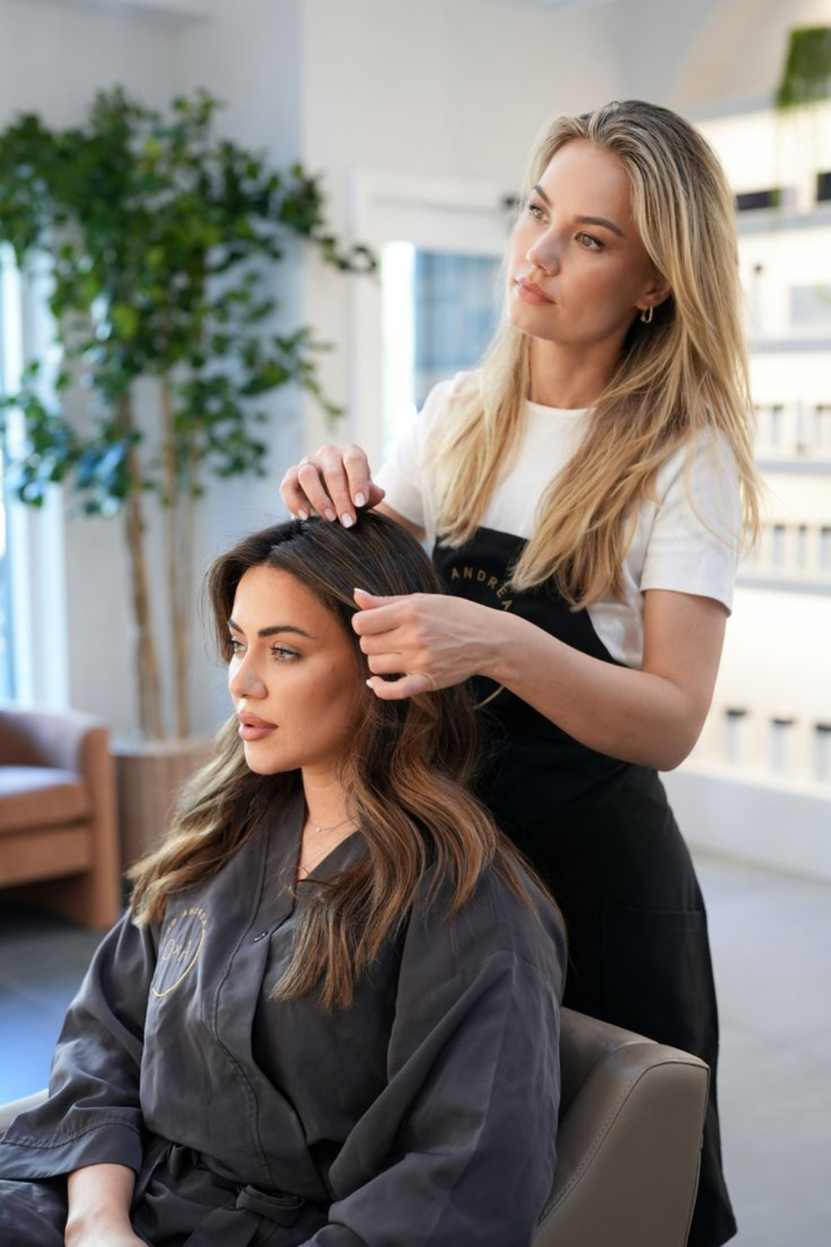 Hairstylist fixing the hair of the women