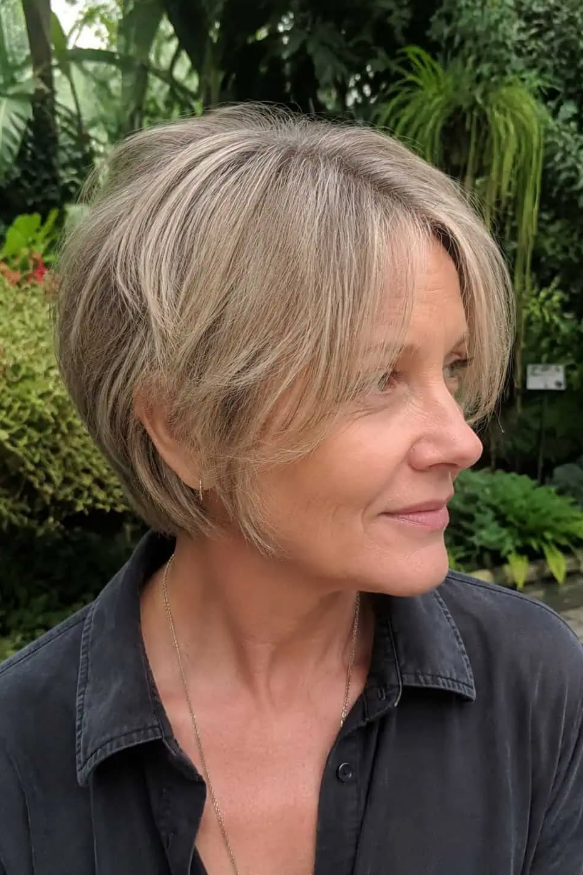 Bixie haircut on a Black woman in her fifties, shorter at the back and longer at the front