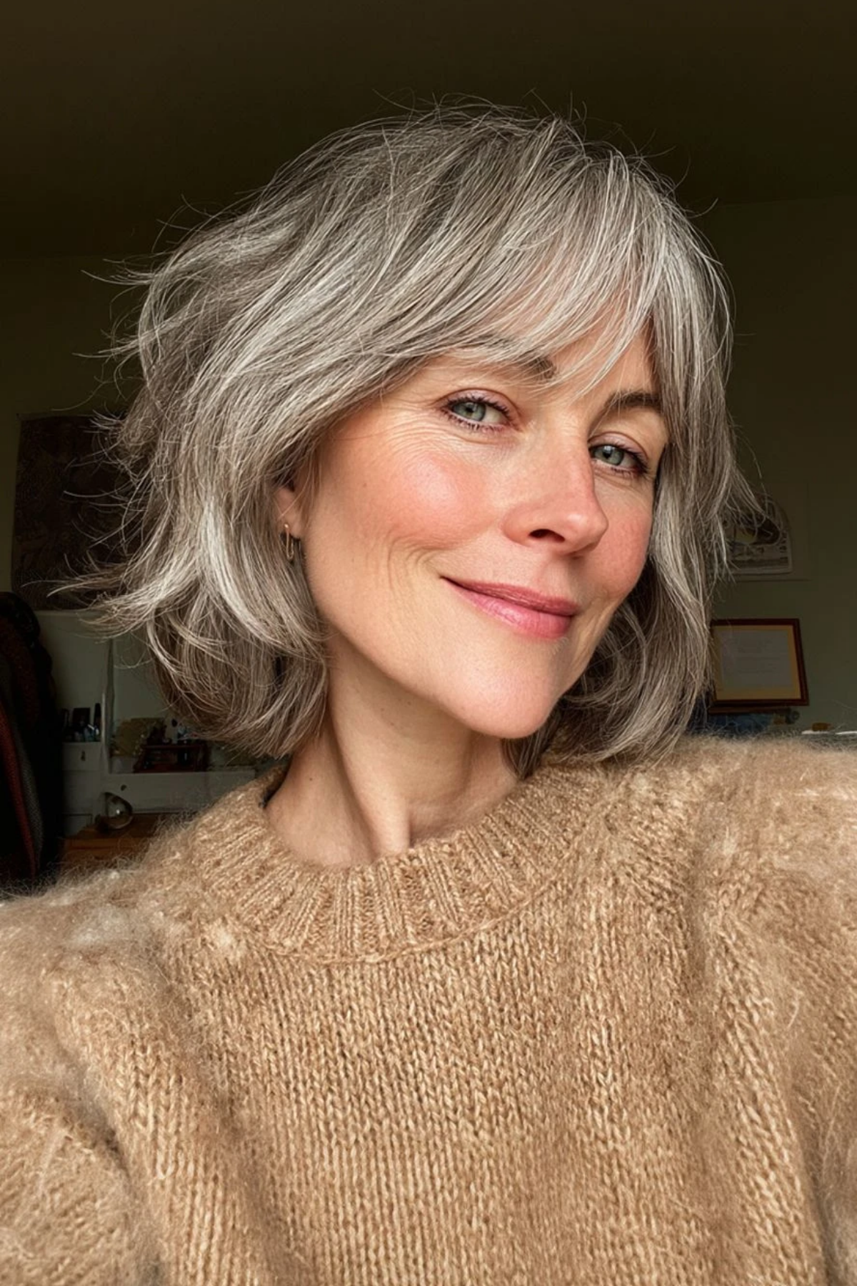 Short shag on thick wavy salt-and-pepper hair on a woman in her fifties