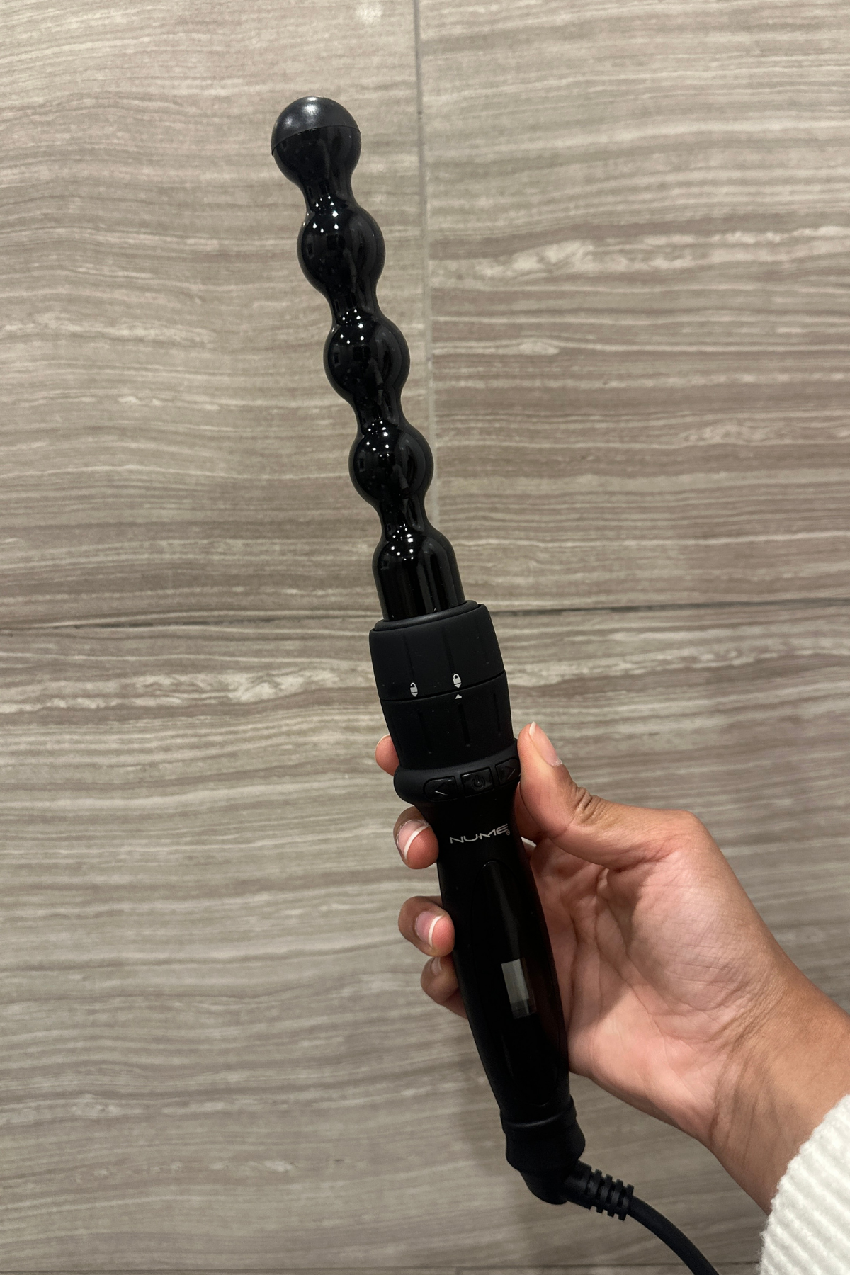 Woman with NuMe Pearl Curling Wand.png