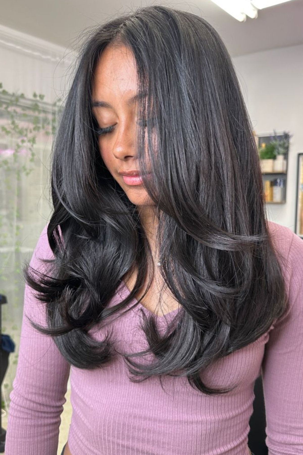 Girl styled in Feathered Long Layers haircut, showcasing soft feathering that adds bounce and keeps hair light in summer.