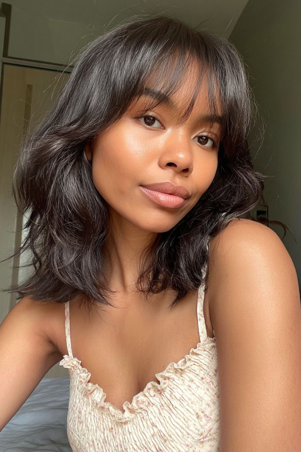 Woman wearing an Airy Shoulder-Length Shag haircut, featuring soft layers that reduce frizz and enhance natural texture.