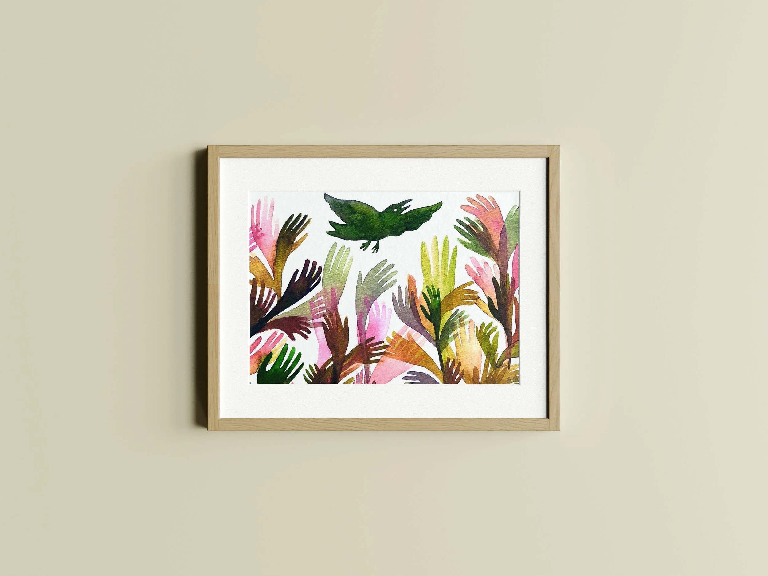 Framed artwork featuring a watercolor design of colorful hand shapes with green leaves, the artwork is made by illustrator Majken Enequist.