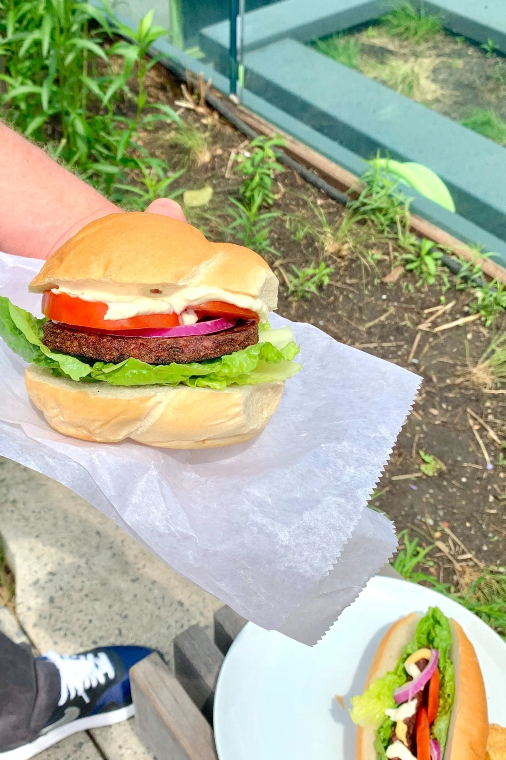 Close Up  Hand Holding Nutty Burger with lettuce and tomatoes