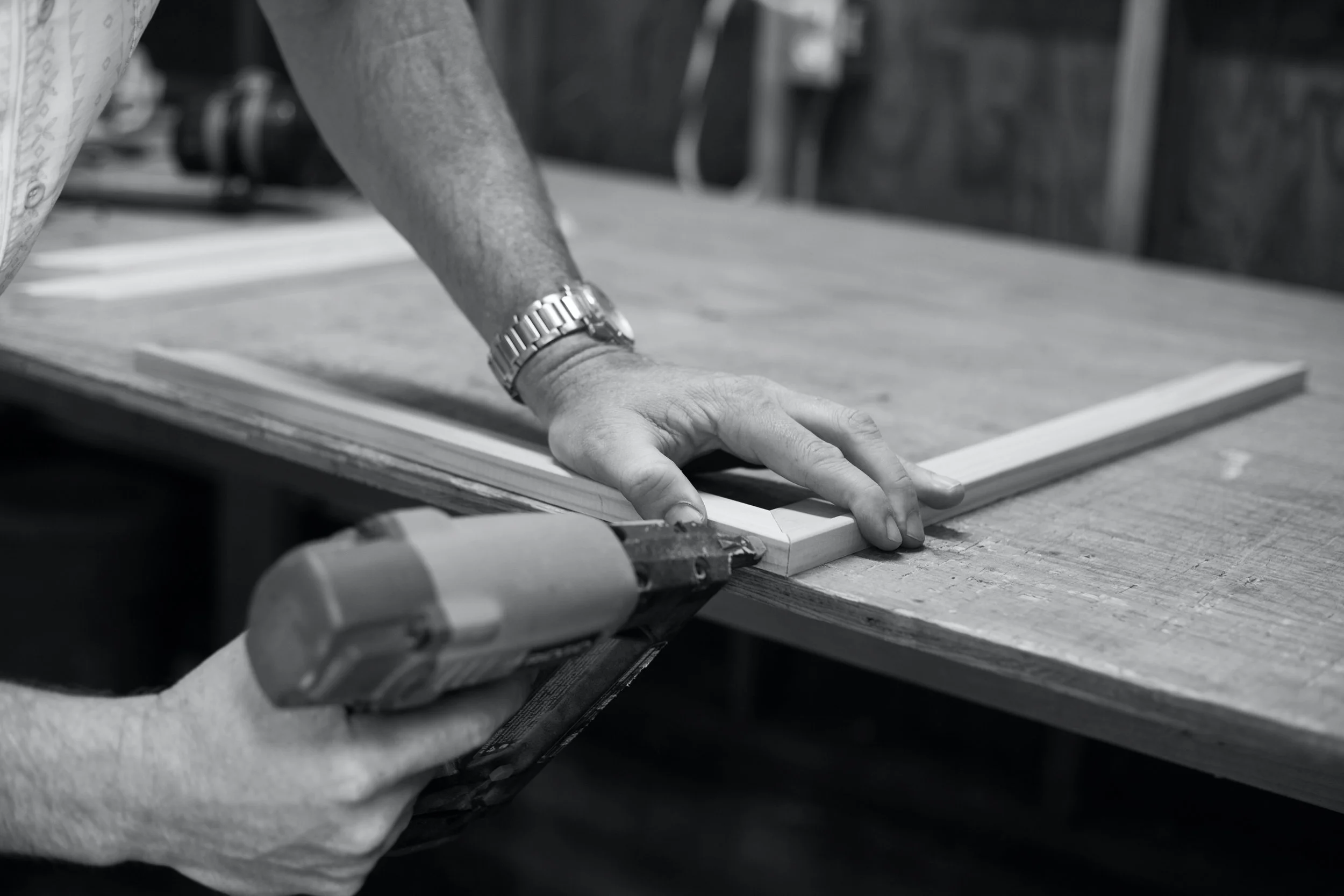 Craftsman joining a wood frame with a nail gun.jpg
