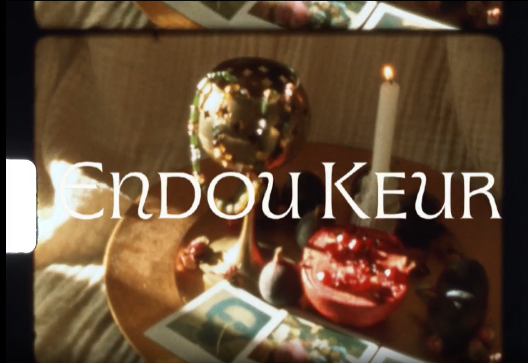 A wooden platter with various cheeses, grapes, strawberries, and a cheese knife. A lit candle is in the background. The word 'CENDOUKeur' is overlaid on the image.
