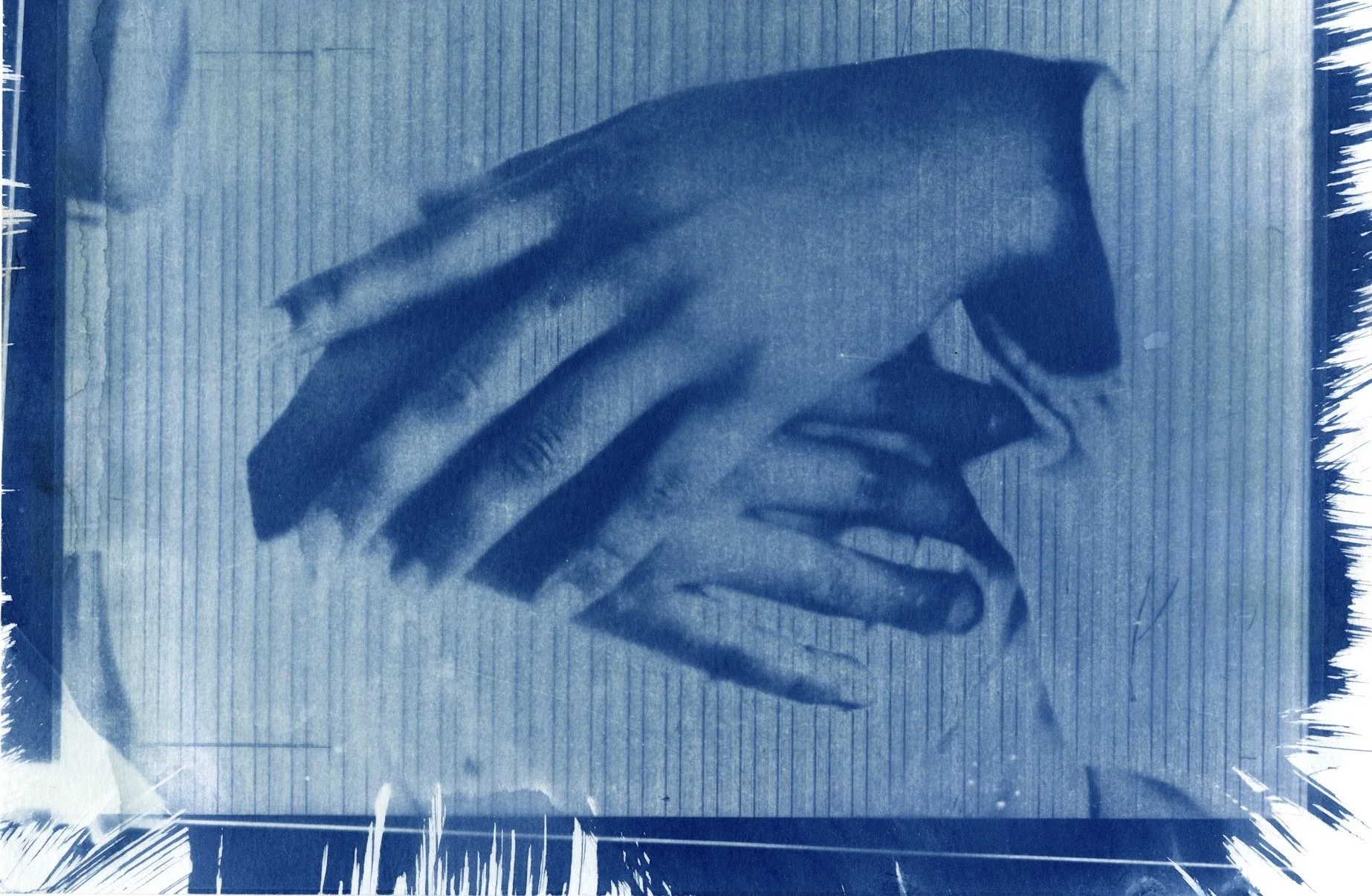 A vinyl record cover featuring a monochrome blue-tinted close-up of a person's face partially obscured by their hand.