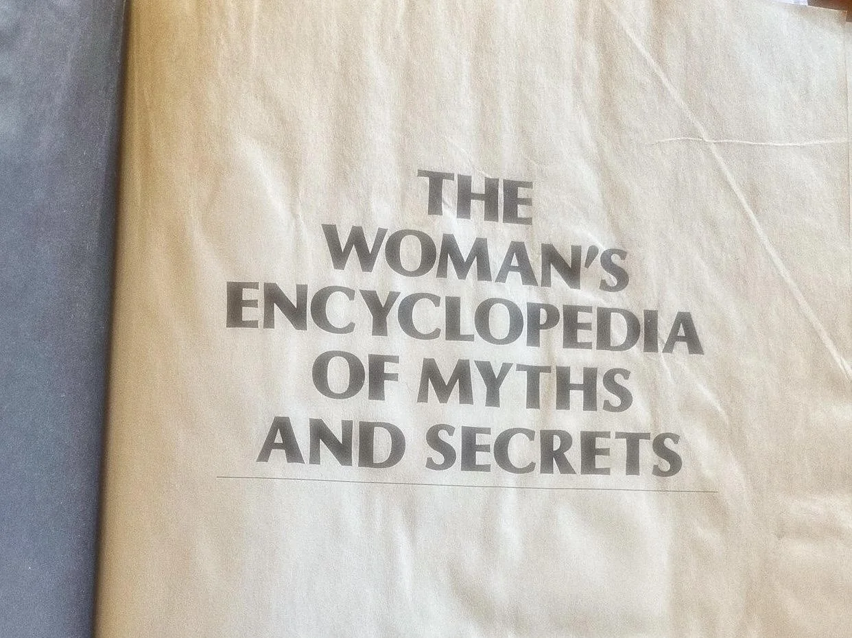 Title page of a book called 'The Woman's Encyclopedia of Myths and Secrets' with text on a beige background.