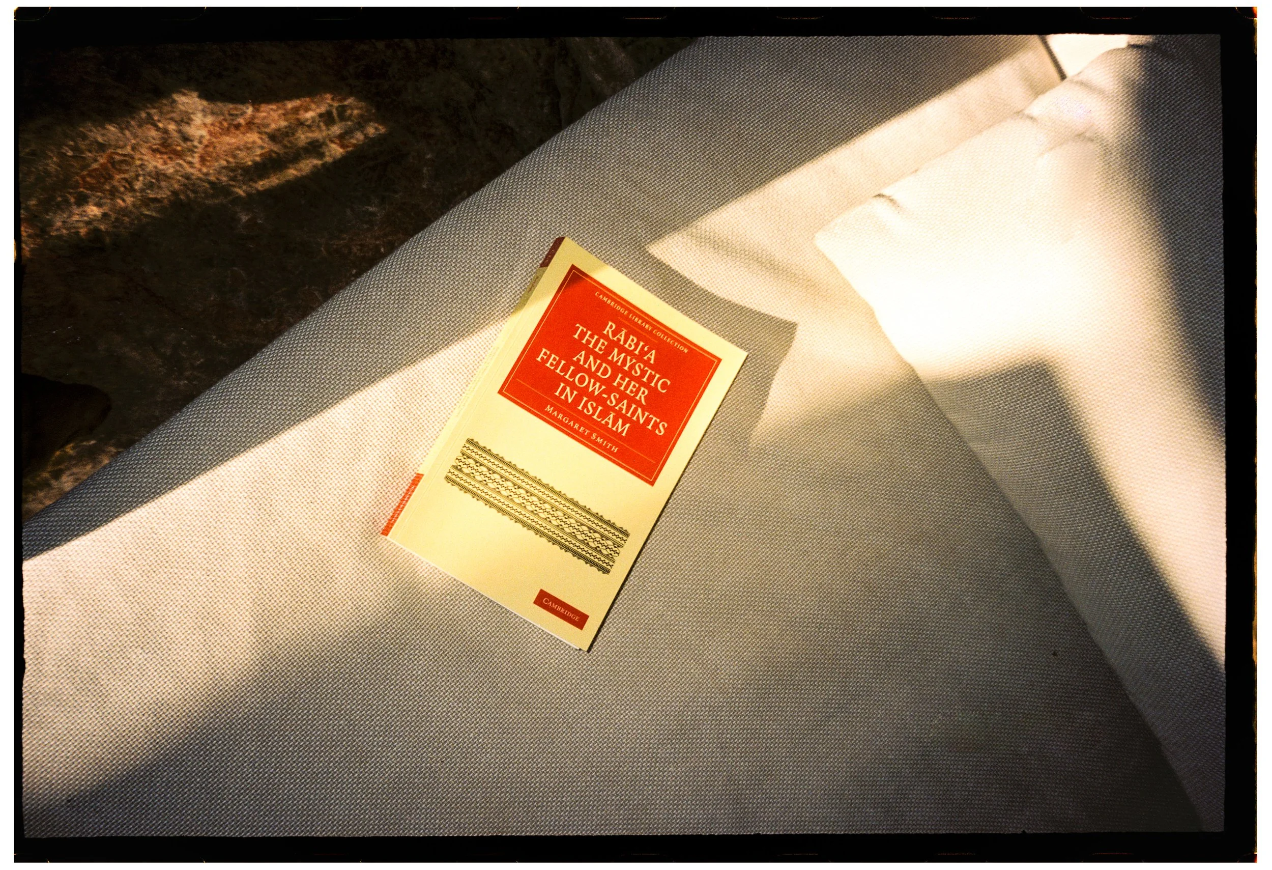 A book titled 'Rabia the Mystic and Her Fellow Saints in Islam' resting on a textured gray surface.