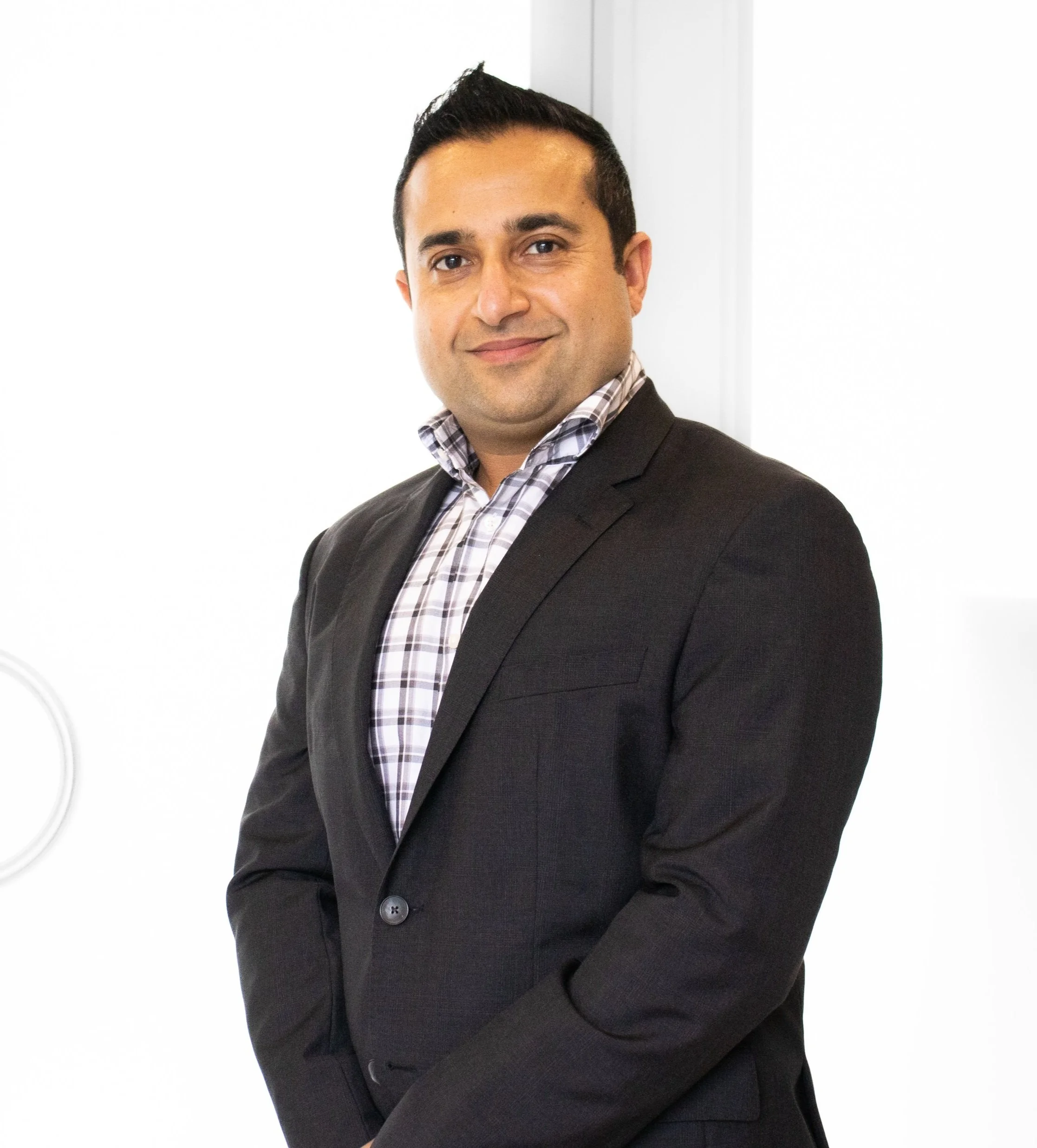 photo of Dr Puneet Mahindra smiling in a suit