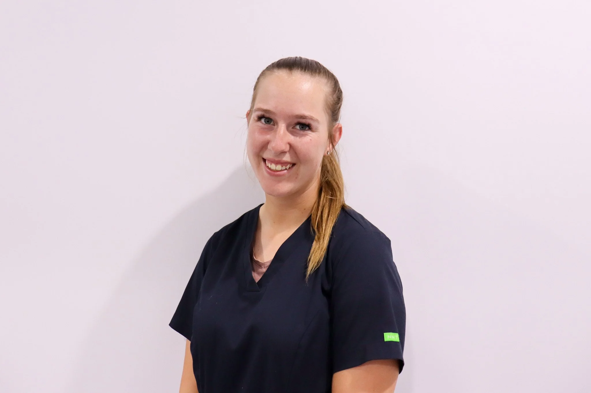 Photo of Lauren smiling in scrubs