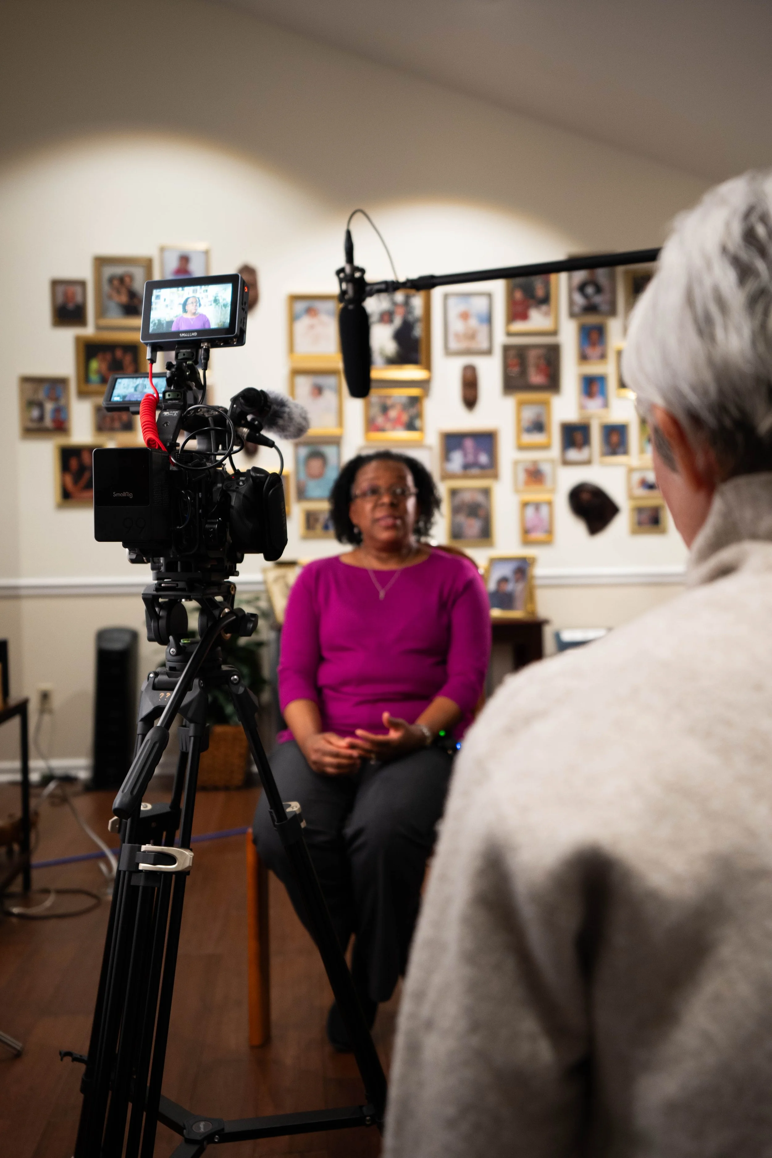 Sony FX6 cinema camera rig filming a subject during an interview with a Rode NTG3 boom microphone overhead and sheer diffusion for soft lighting