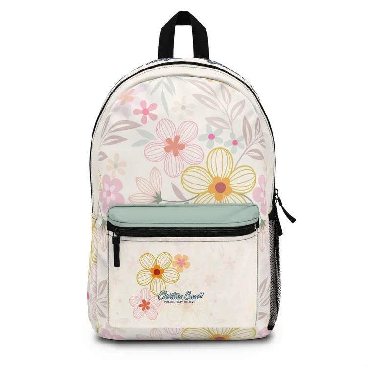 A floral-patterned backpack with pastel-colored flowers on a white background, featuring a front pocket with the Christian Crest logo and the words 'Praise. Pray. Believe.'