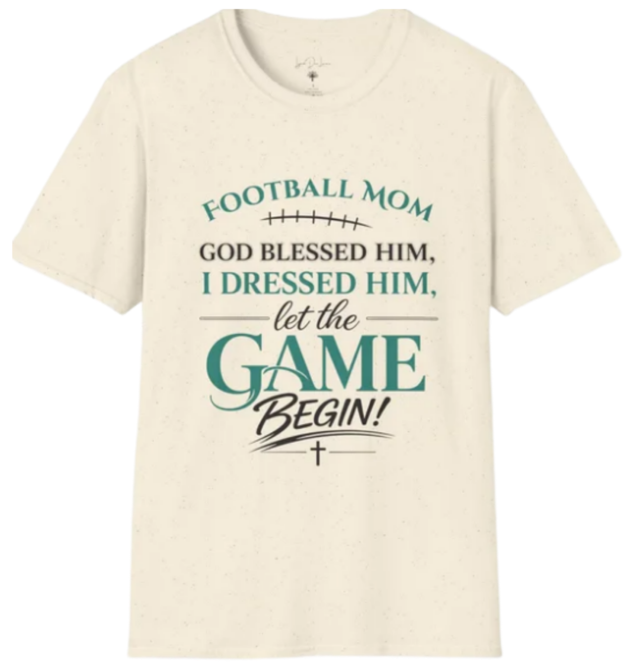 A white T-shirt with a sports-themed quote that reads "Football Mom God blessed him, I dressed him, let the game begin!" in various fonts and colors, with a small cross symbol at the bottom.