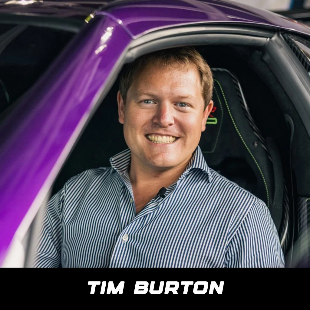 Tim Burton thumbs up beside his purple Mercedes Benz sports car