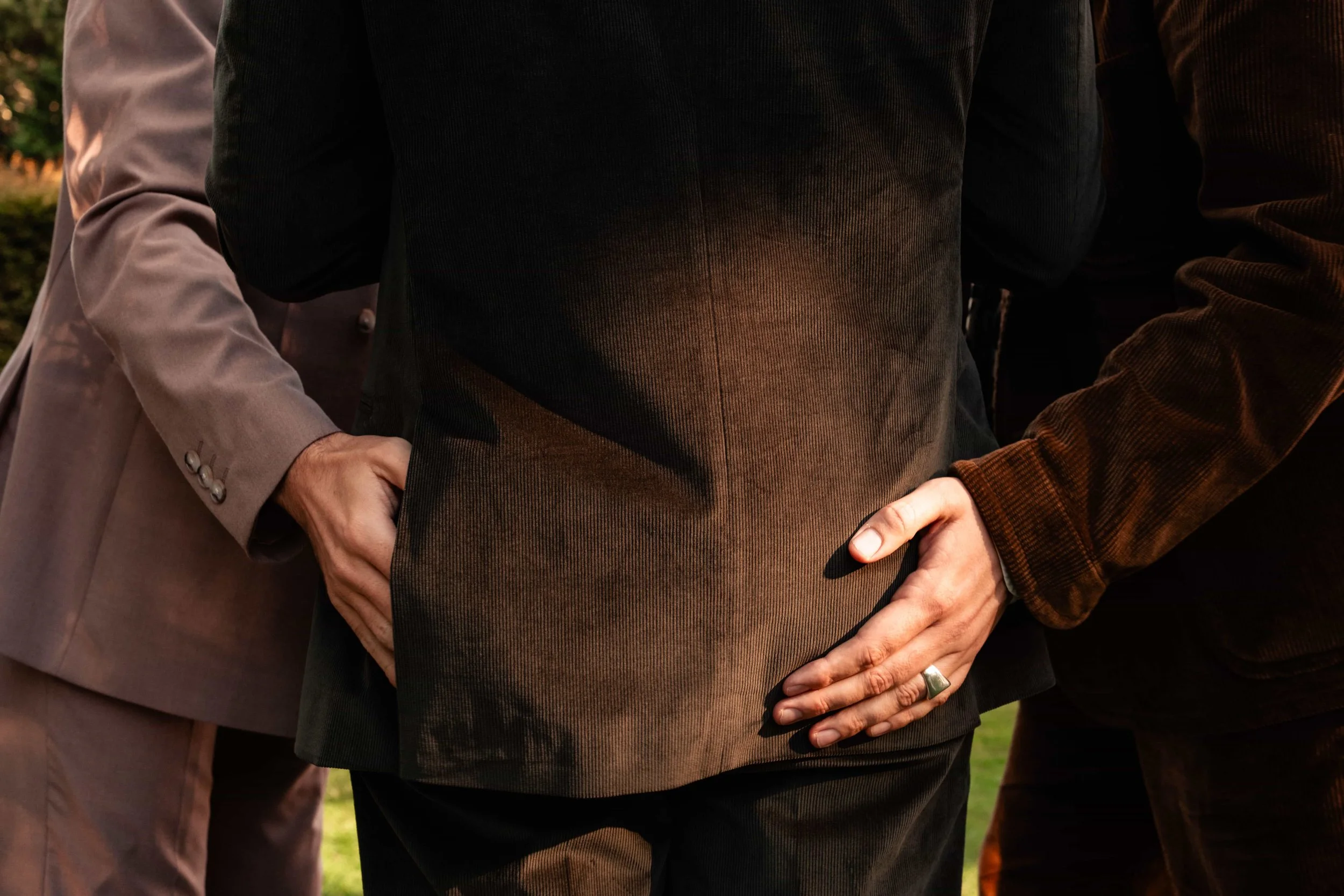 Guests jokingly pat the groom during wedding celebrations, creating a playful moment.