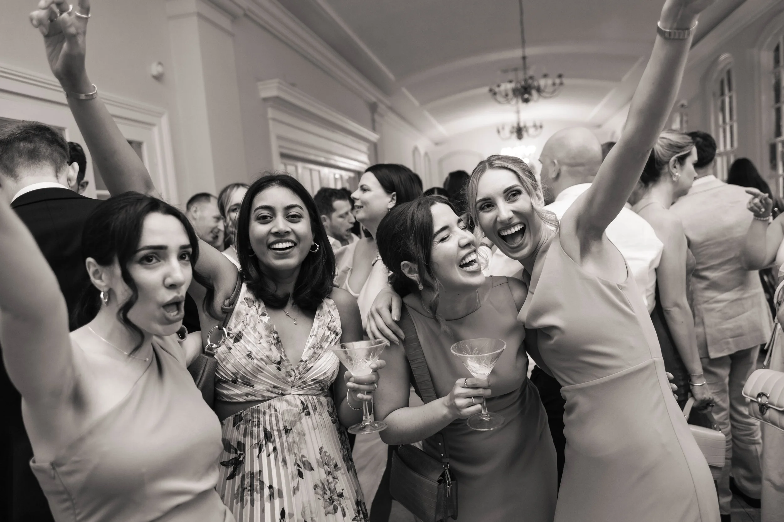 Four women dancing together during a wedding party.