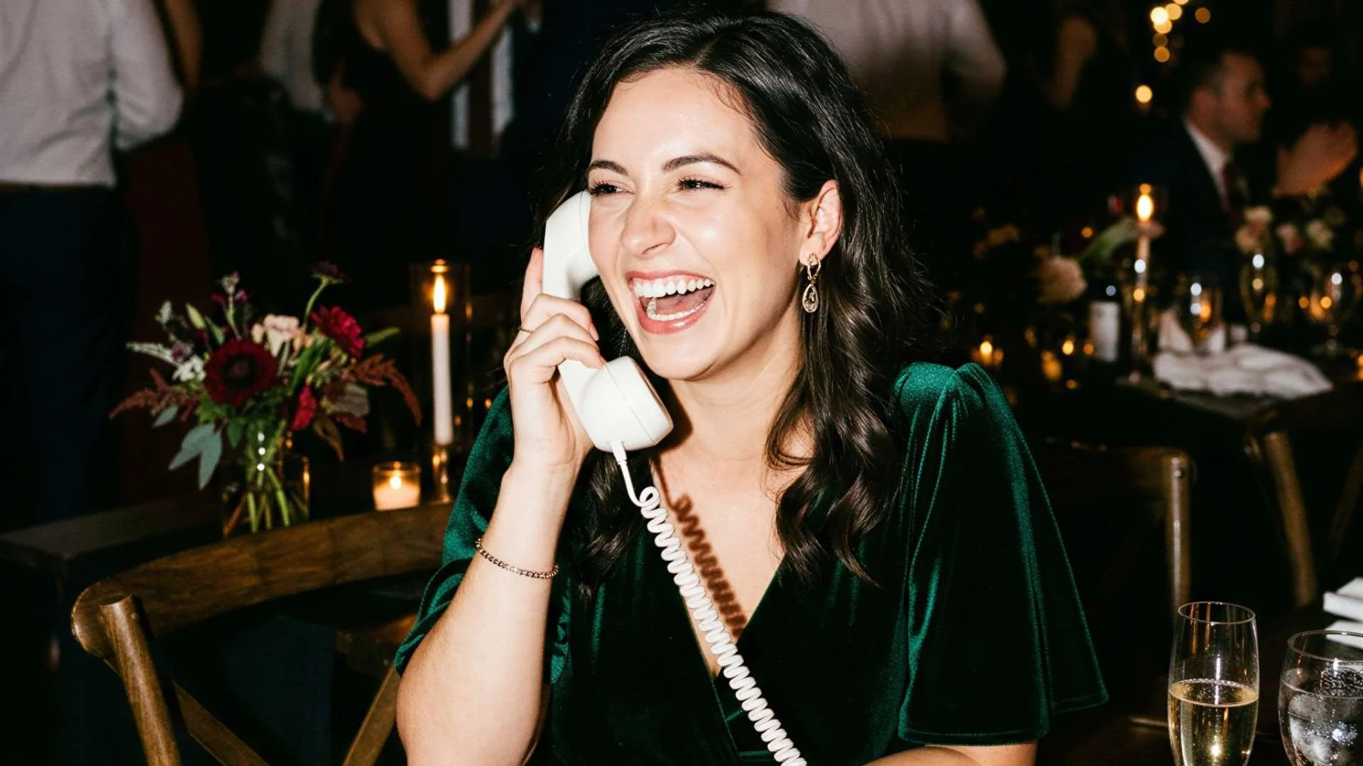 woman laughing while using a audio guestbook phone at a wedding.