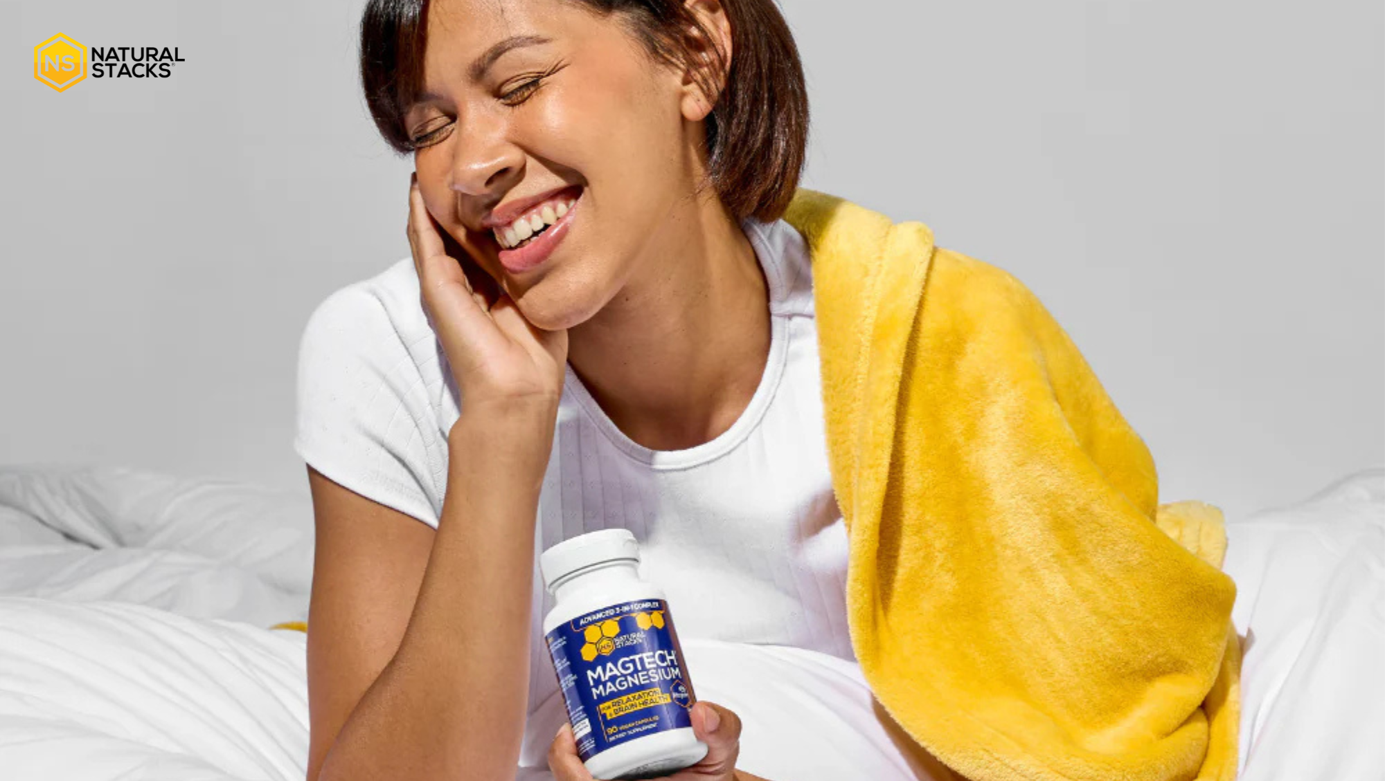 Women smiling holding a bottle of supplements