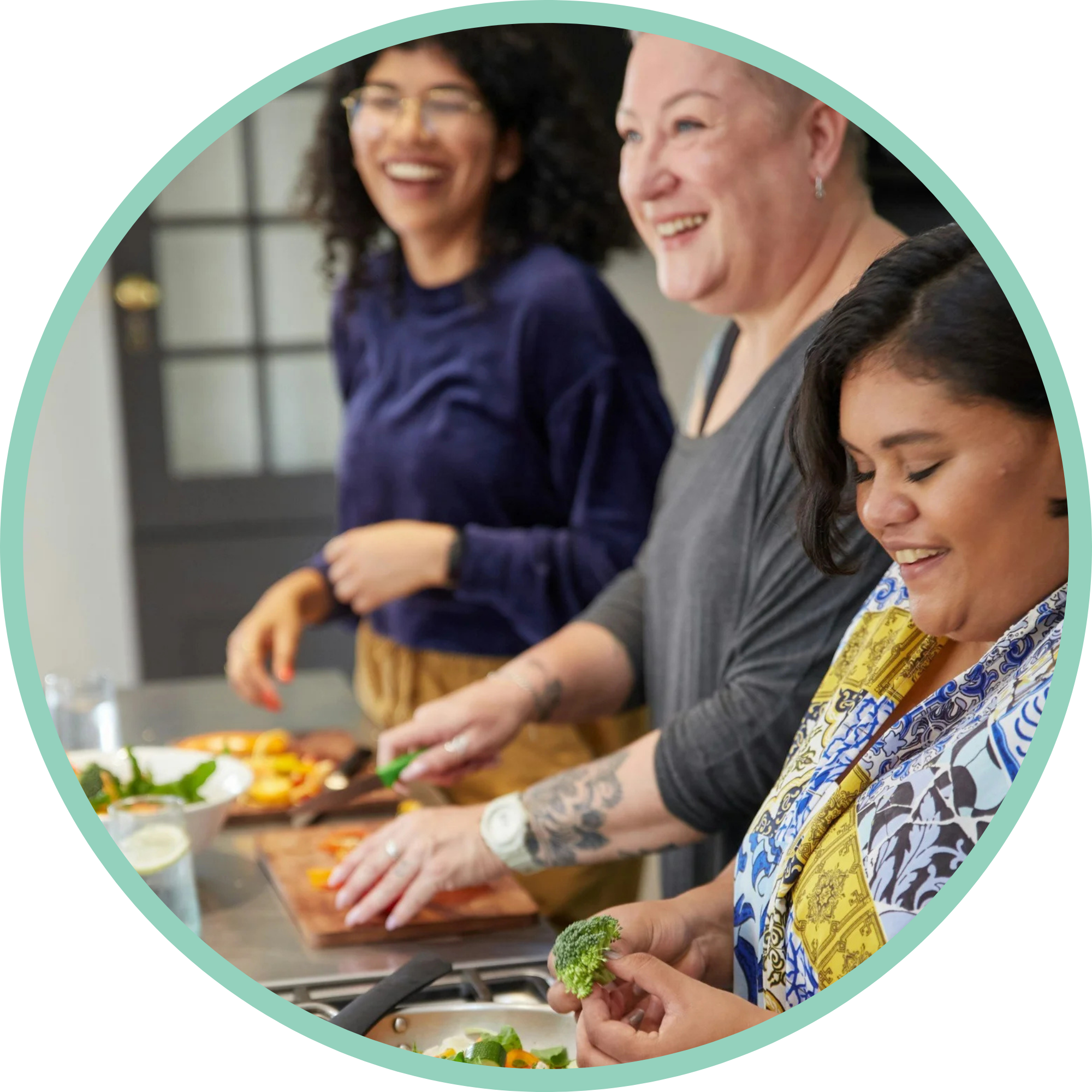 People preparing and making salads together in a kitchen.