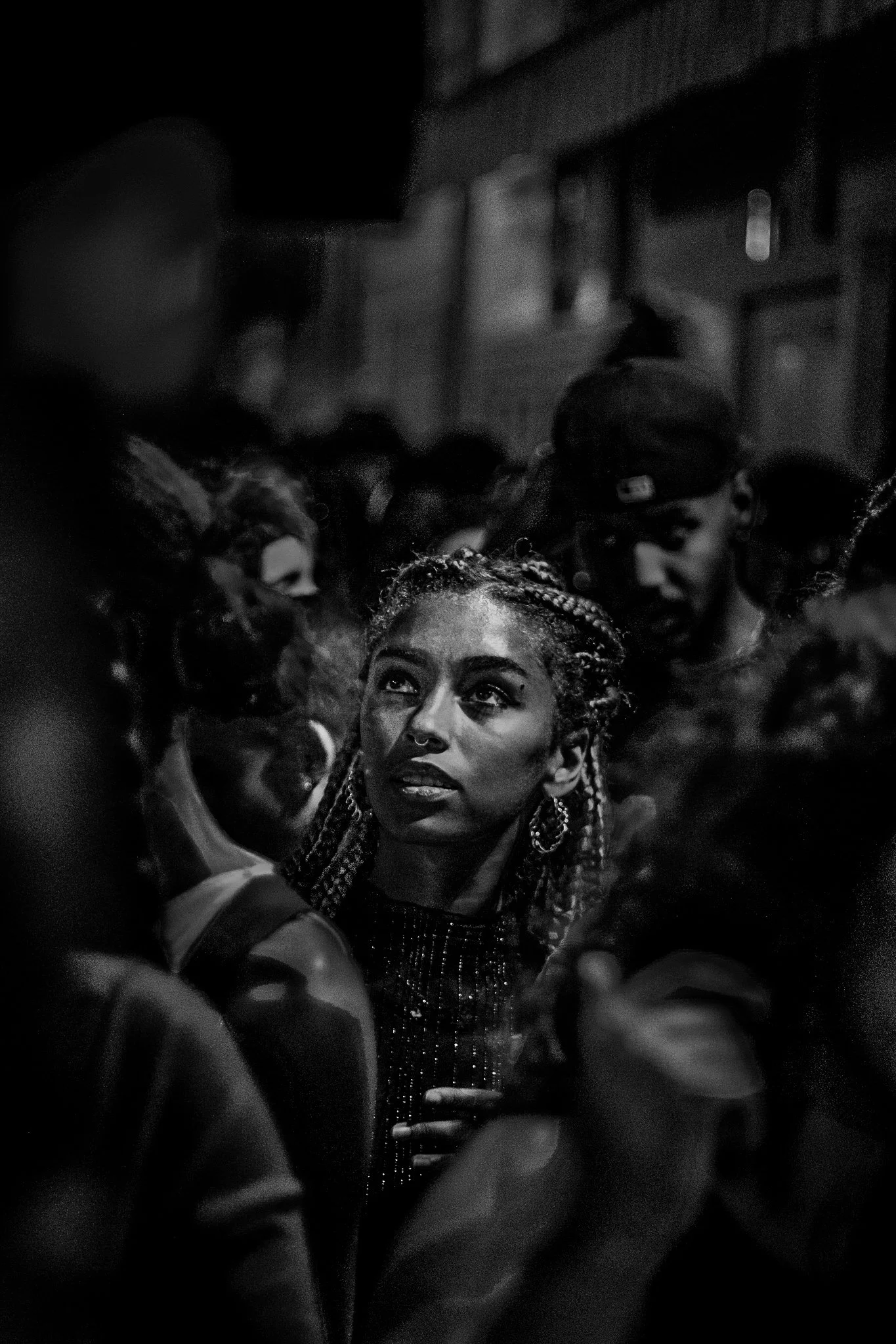 Une jeune fille regardant de manière adminiratif le podium DJ avec une douche de lumière sur son visage.