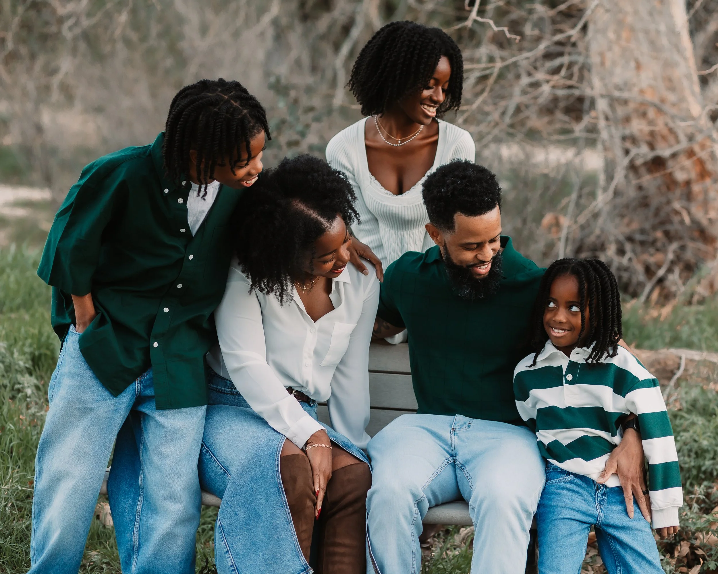 Family of five laughing together around a park bench in Santa Clarita