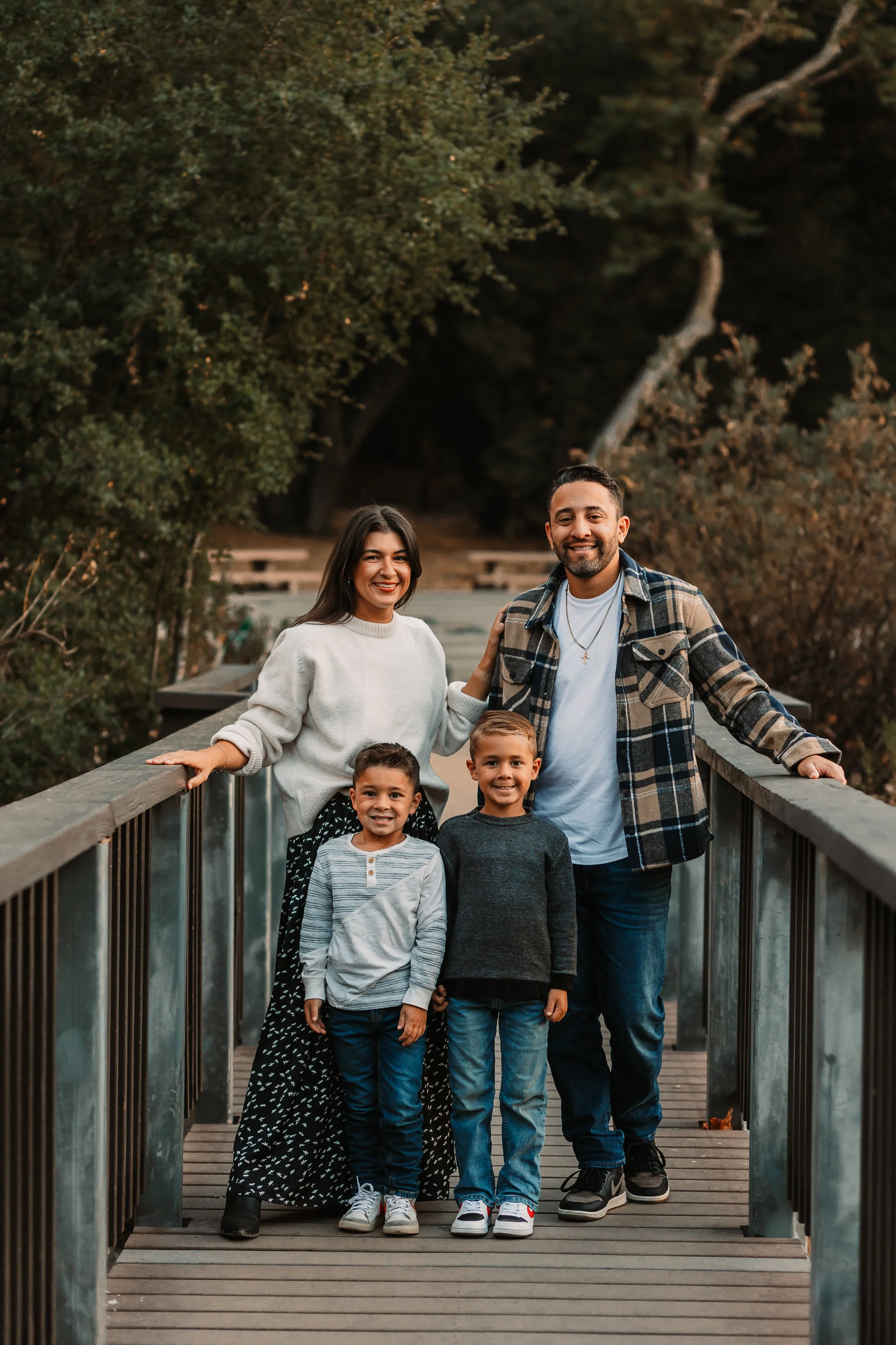 Family of four smiling on a wooden bridge at golden hour, Santa Clarita