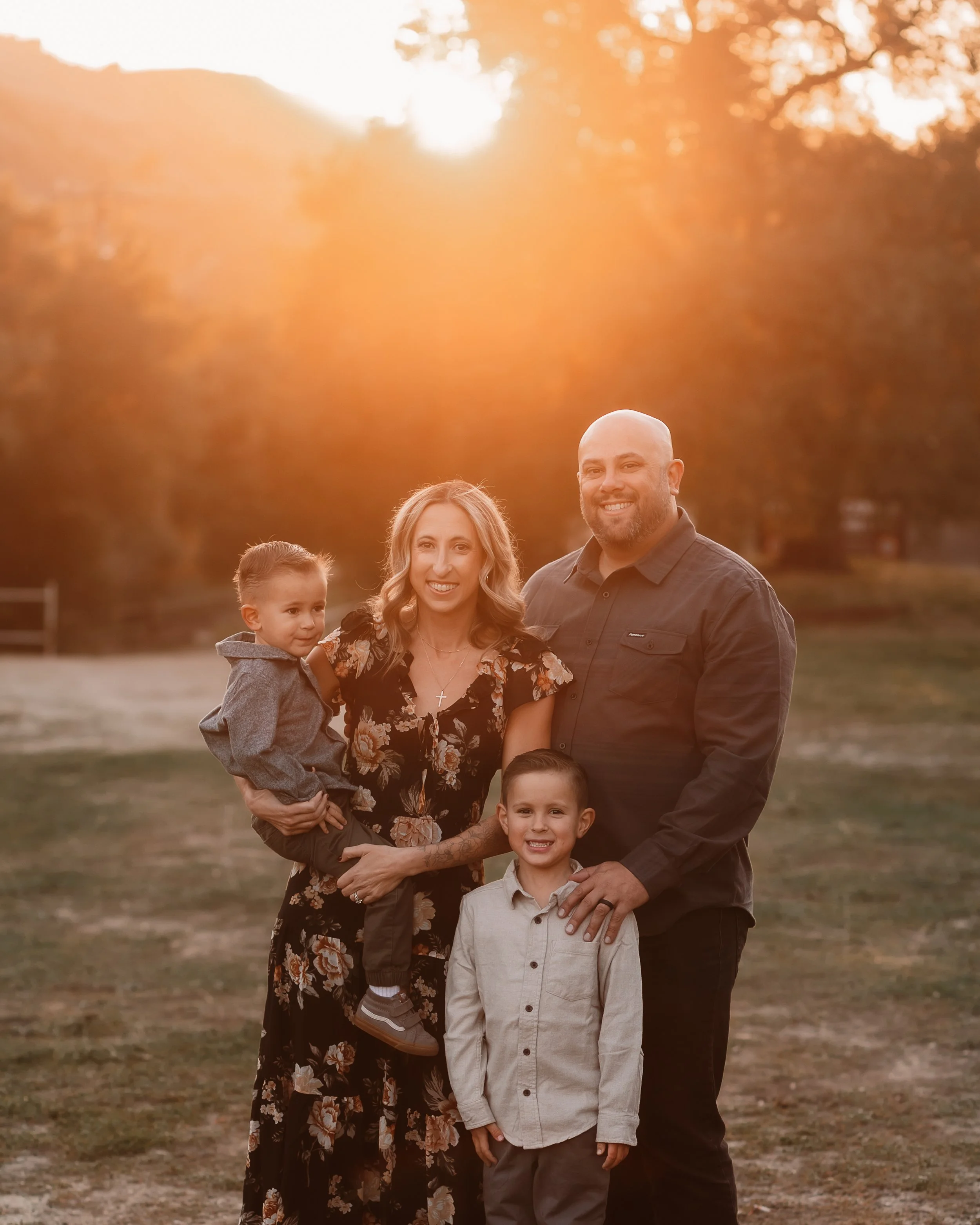 Family of four smiling together at sunset with golden light, Santa Clarita