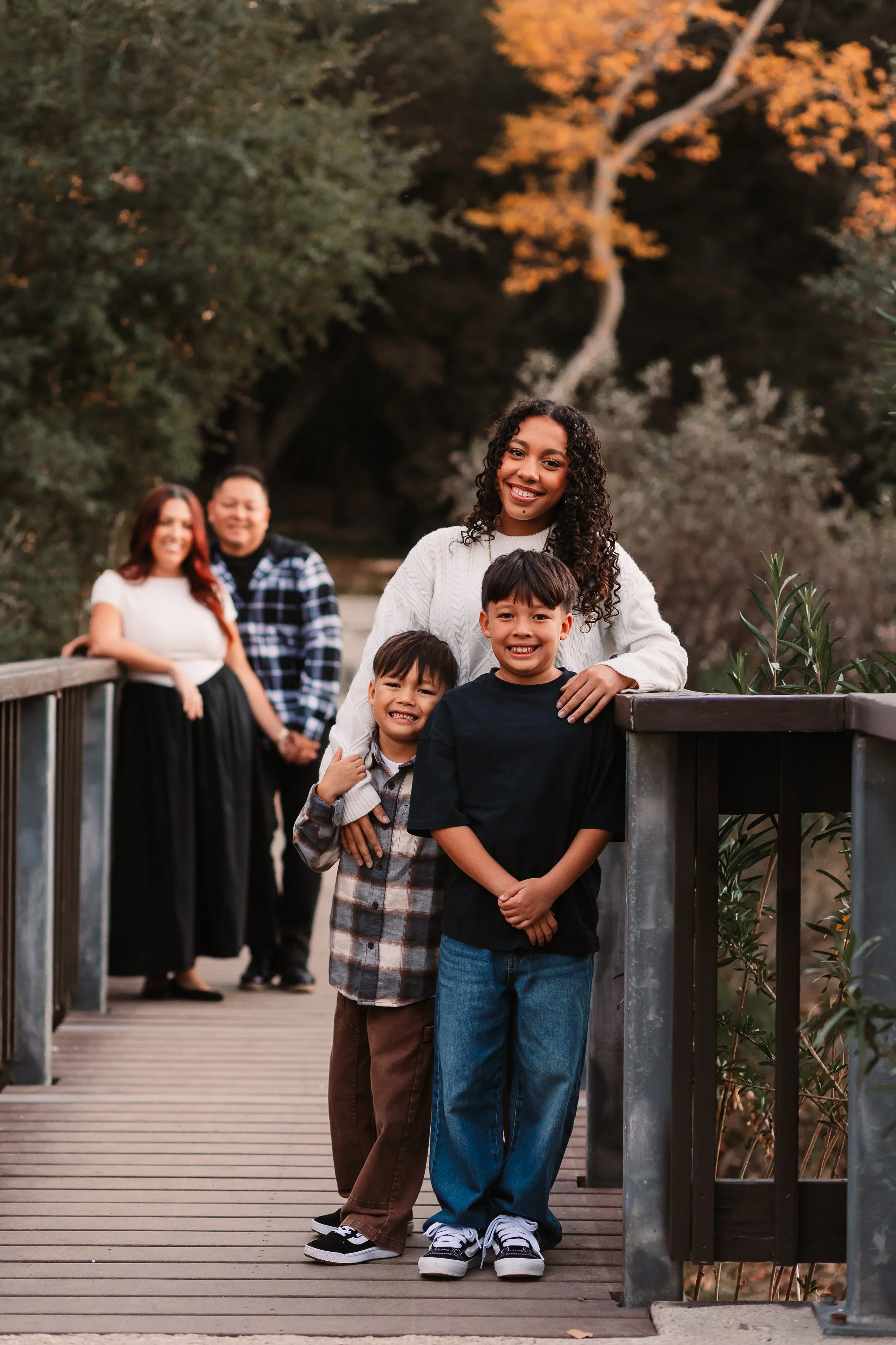 Family of five smiling on a wooden bridge at golden hour, Santa Clarita