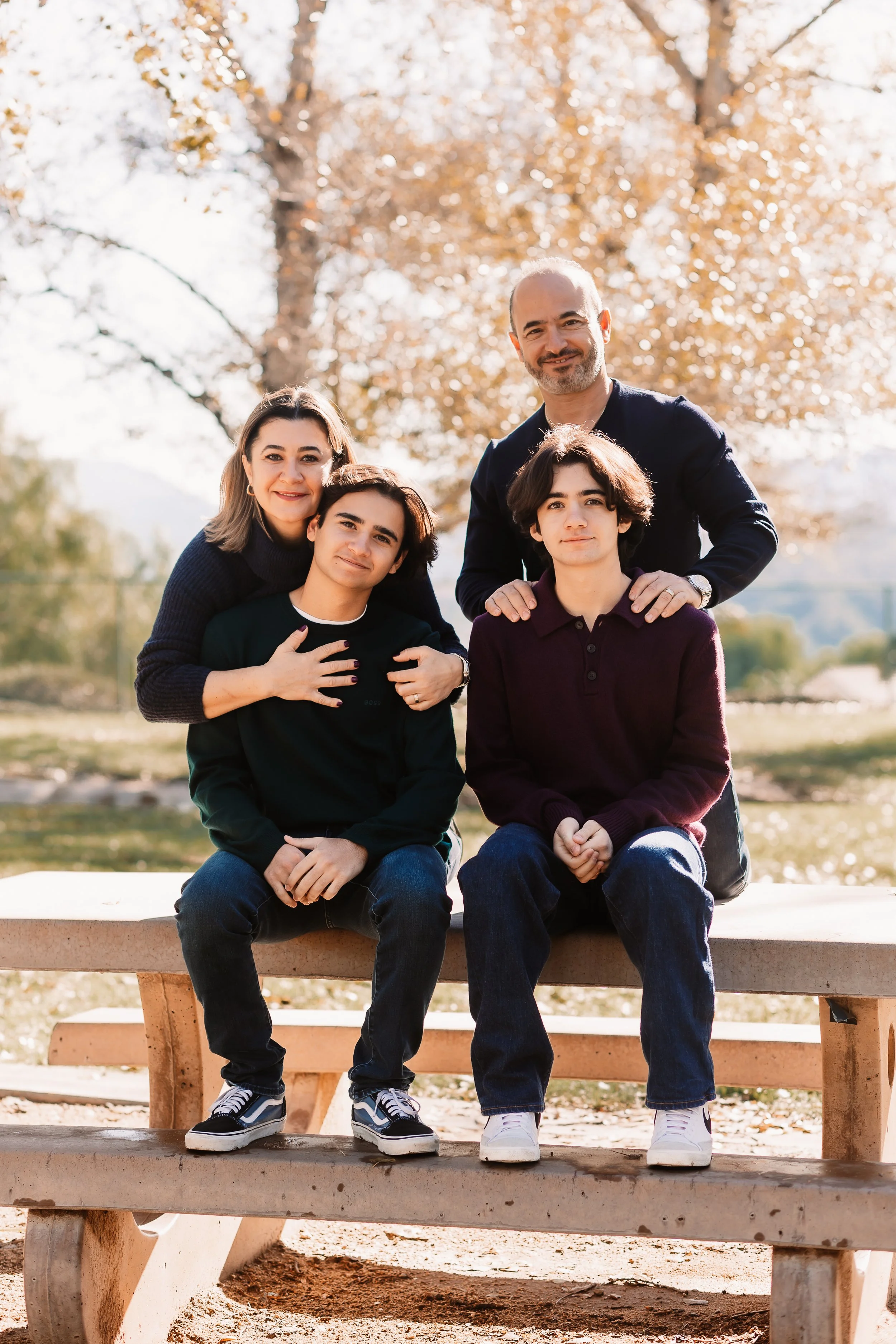 Family of four on a park bench in warm golden light, Santa Clarita