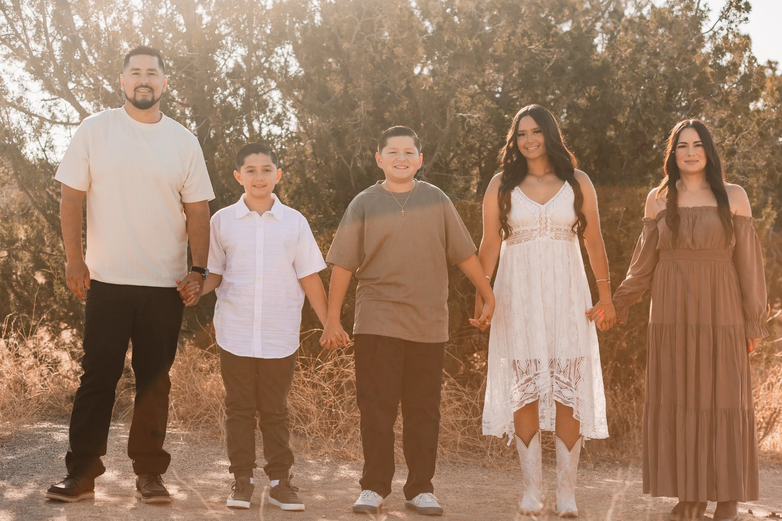 Family of five holding hands in a golden hour field in Santa Clarita
