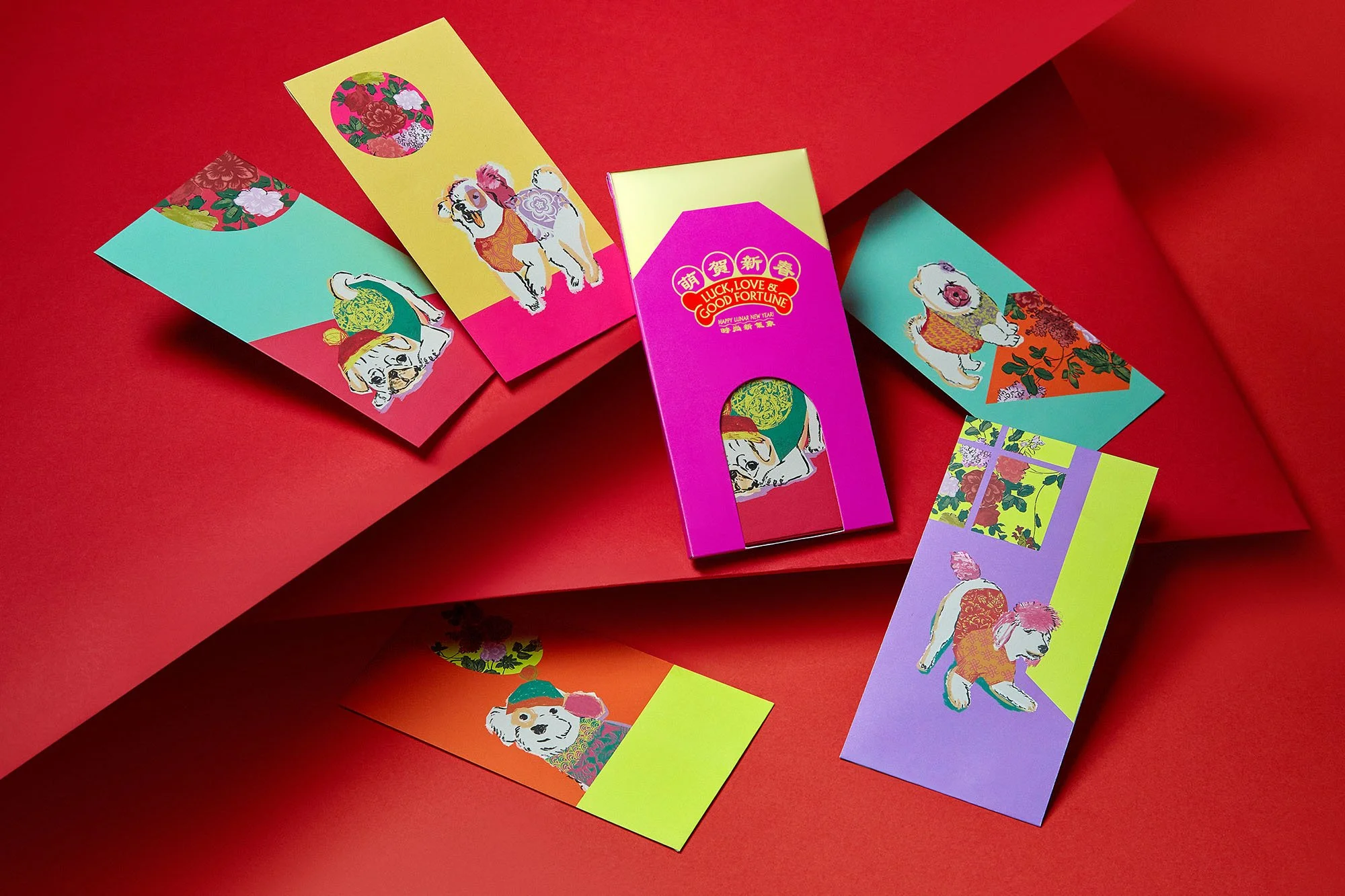 Colorful Chinese New Year red envelopes featuring dog illustrations in various artistic styles, arranged on red paper.