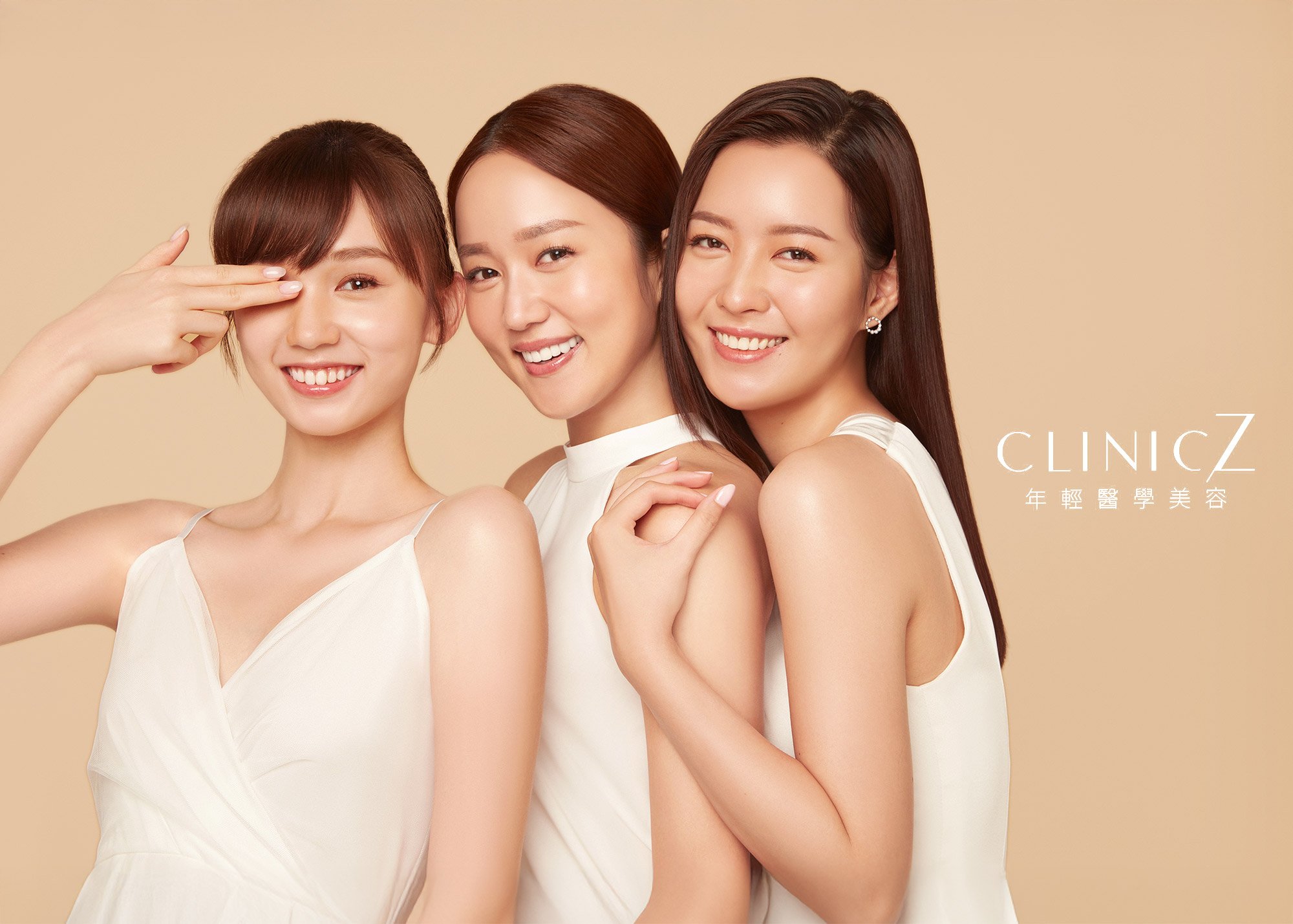 Three young women smiling and posing together against a beige background,