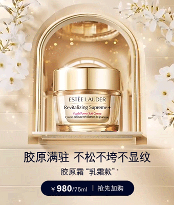 A jar of Estée Lauder Revitalizing Supreme Youth Power Soft Creme displayed in front of a mirror with white flowers and golden decorations.