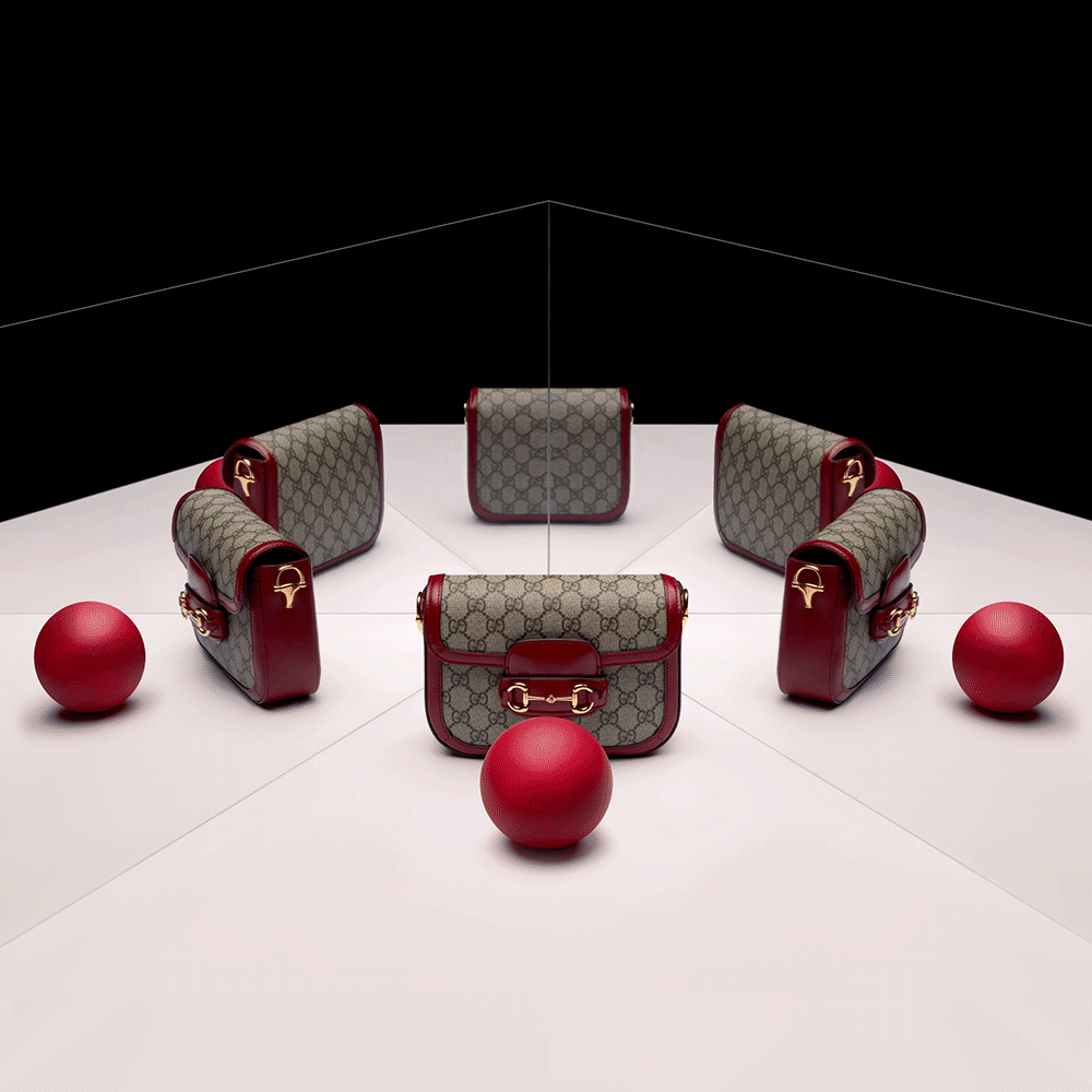 Six luxury handbags with a Gucci pattern and red leather accents are arranged in a circular pattern. Three red balls are placed in front of each handbag, with one at the center. The background is divided into a white lower half and black upper half.