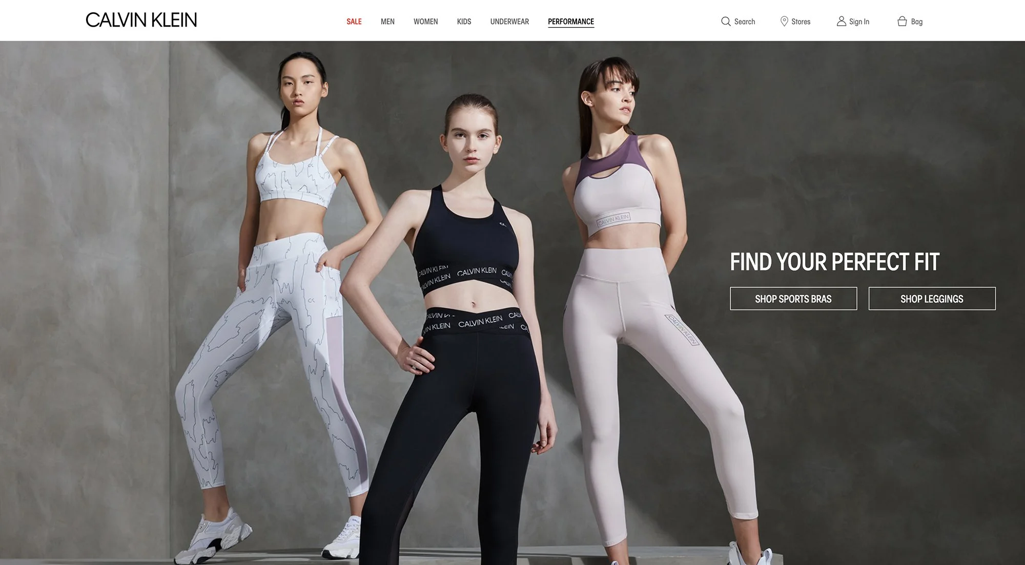 Three women modeling sportswear in front of a plain wall. They are wearing matching athletic outfits and sneakers, with confident poses. The website header shows brands and categories, and a section on the right promotes shopping for sports bras and 