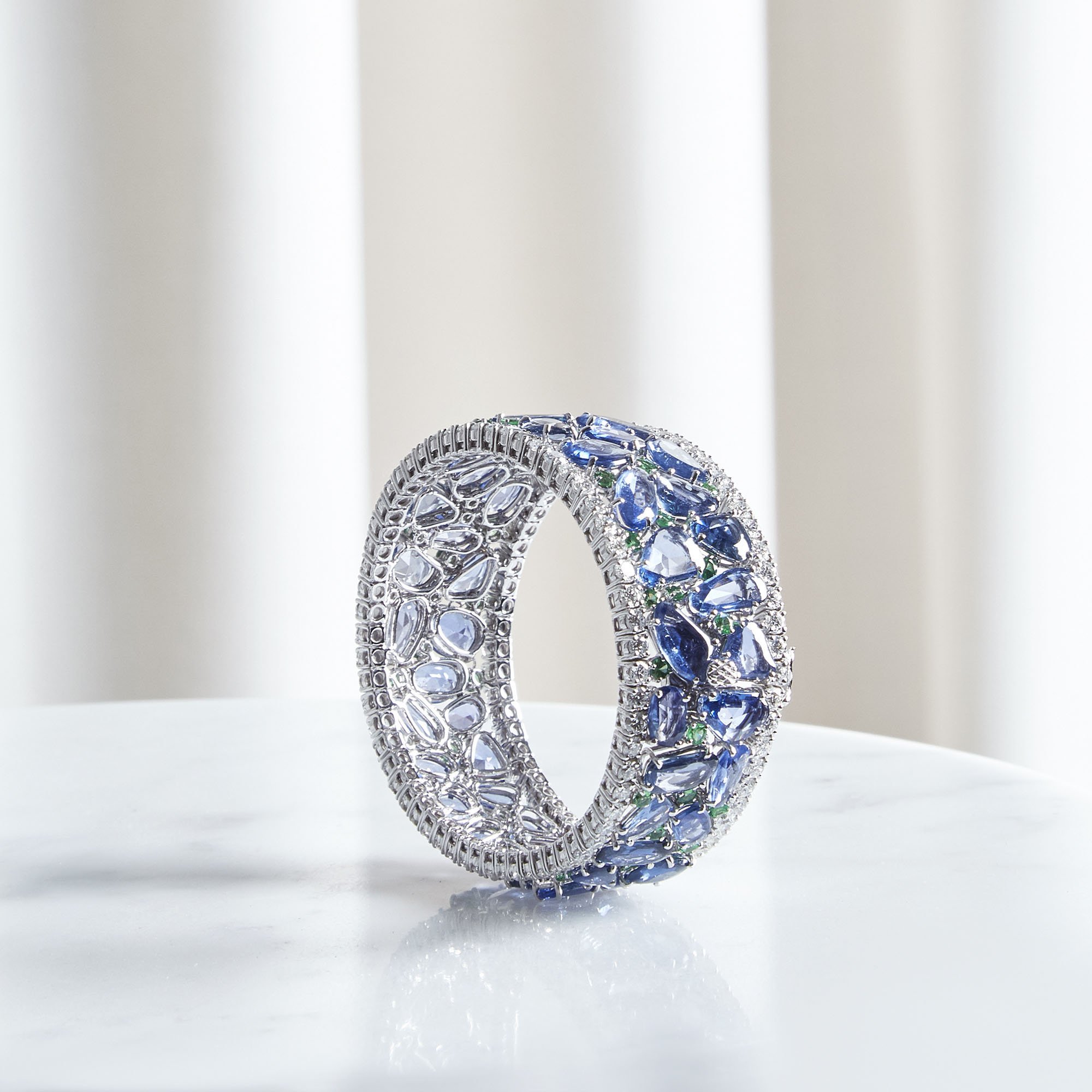 Elegant silver ring with blue and clear gemstones, displayed against a white background.