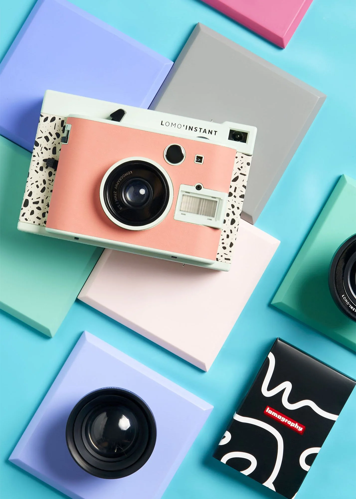 Colorful slides and cameras arranged on a bright blue background, featuring pastel and bold hues.