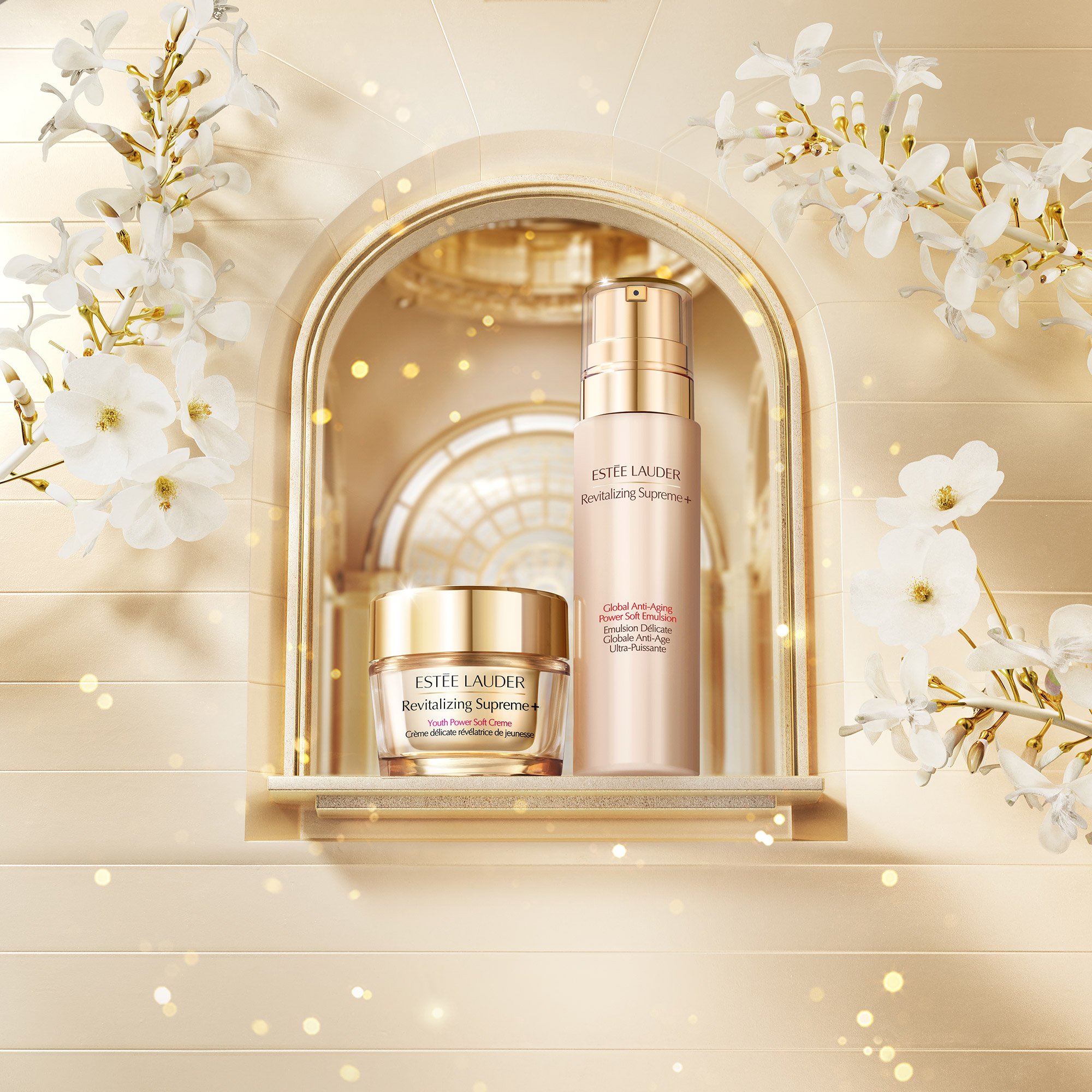 Estée Lauder skincare products, a jar and a pump bottle, on a shelf with a decorative mirror and white flowers, lit with warm, golden light.