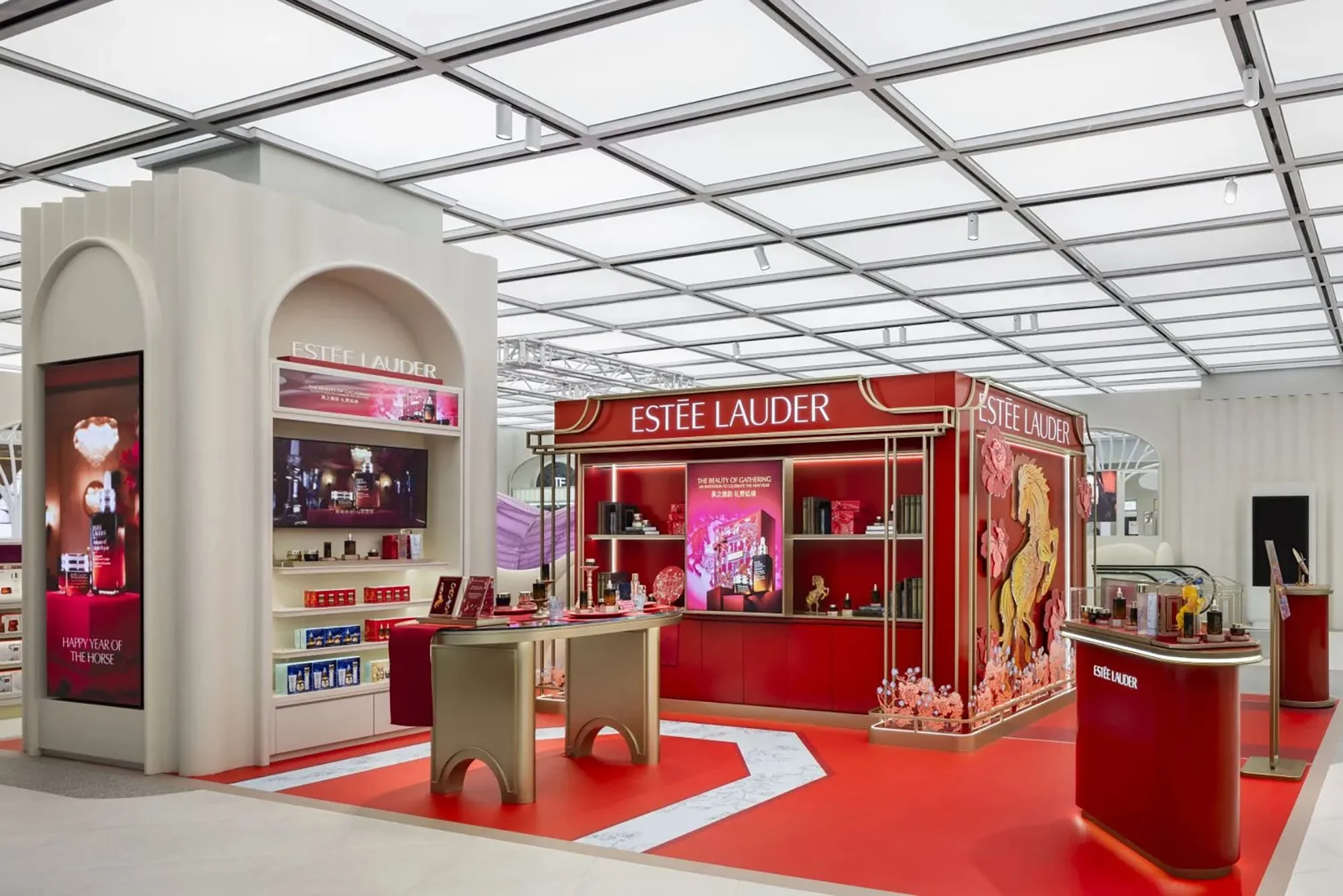 Beauty and skincare display booth for Estée Lauder in a retail store with red and white decor.
